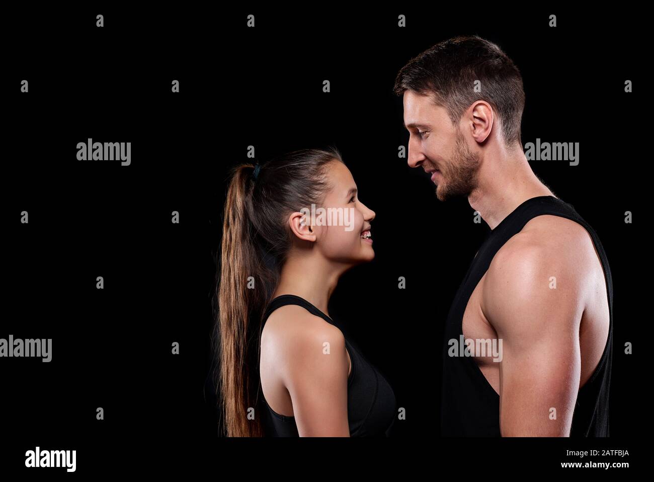 Felice giovane sportivo e sportivo in abbigliamento sportivo guardando l'uno l'altro Foto Stock