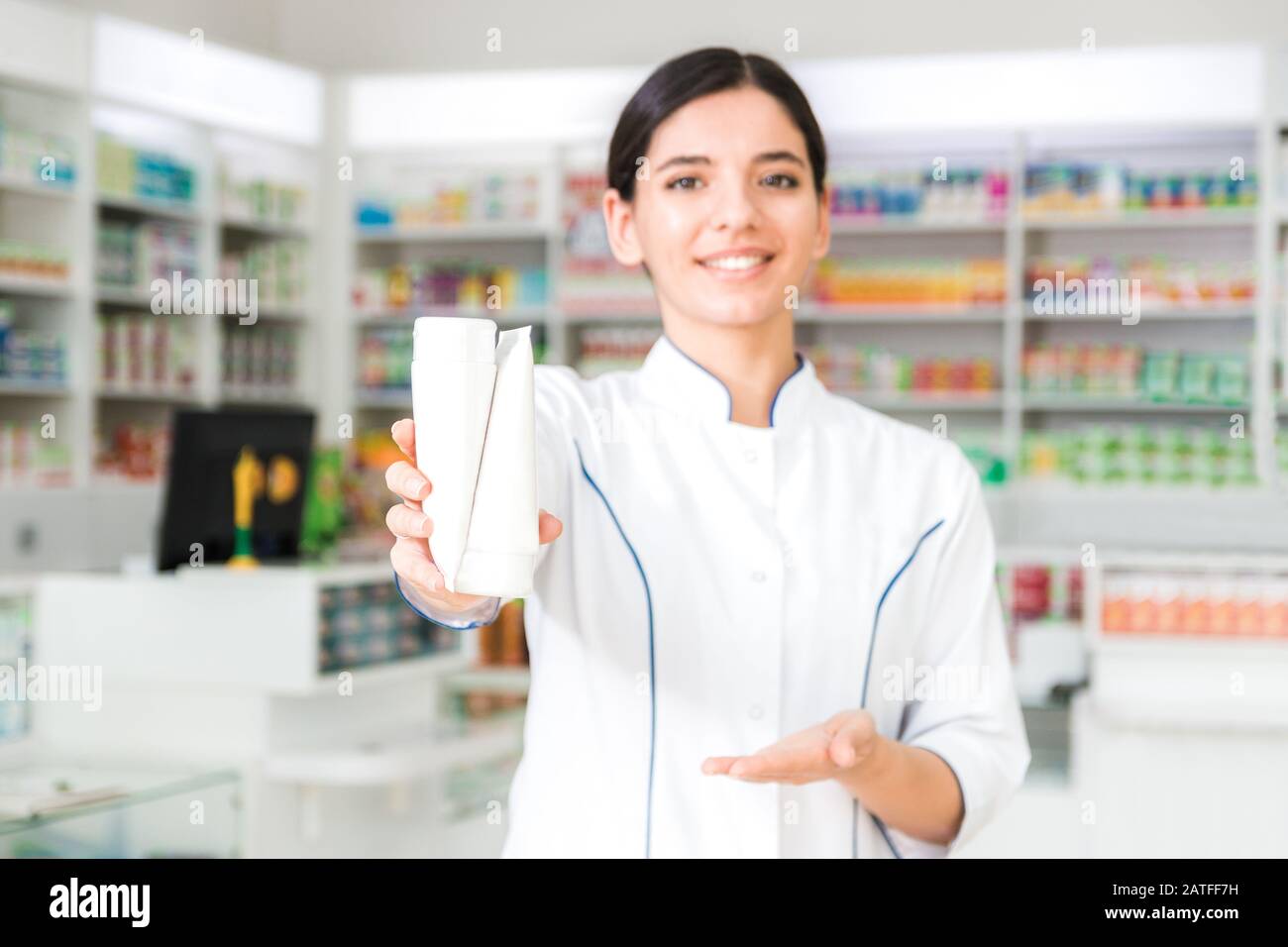 attraente farmacista che tiene due vasi bianchi. prodotto pubblicità Foto Stock