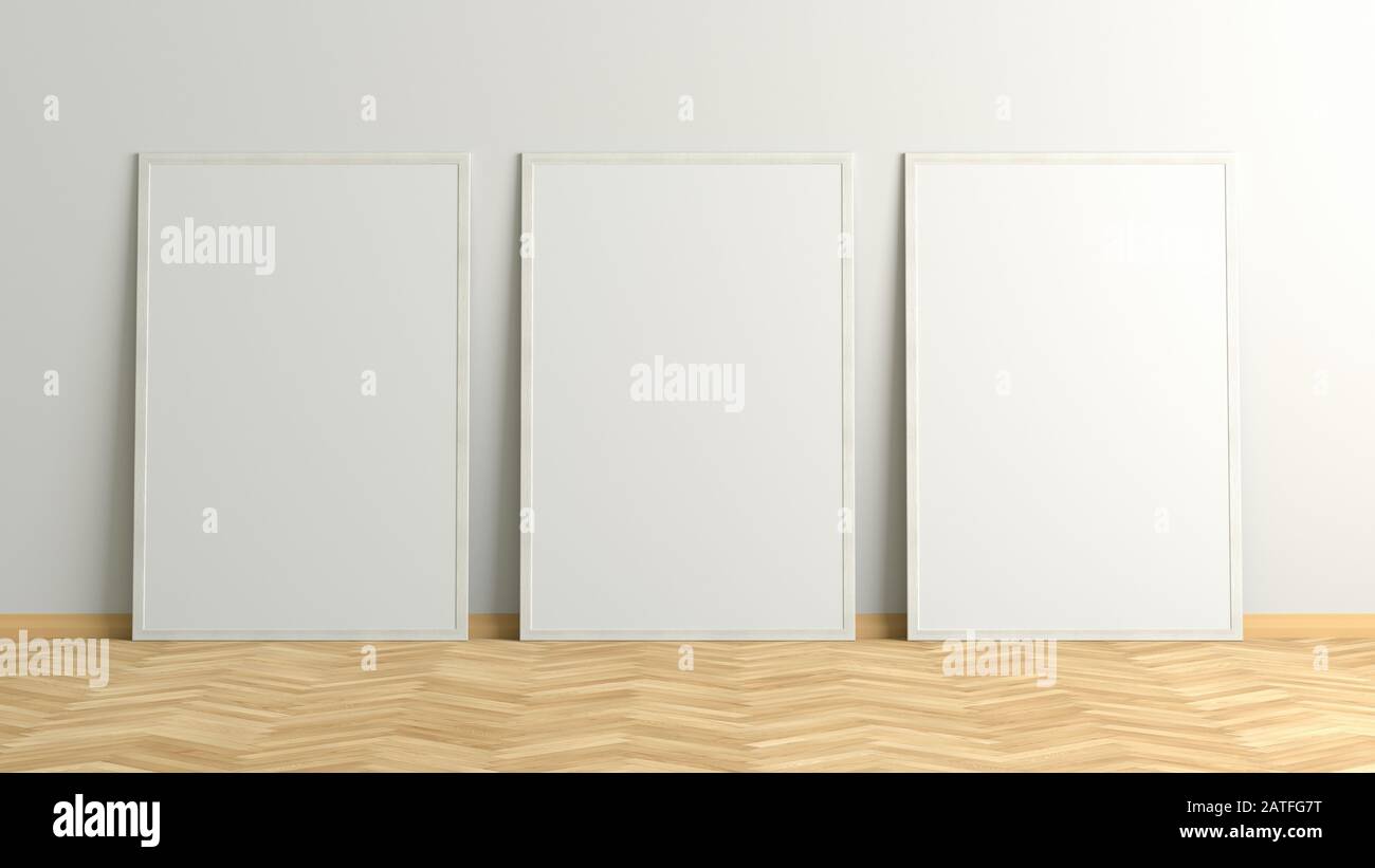 Tre poster verticali. telaio modellato in piedi su un pavimento in parquet a spina di pesce chiaro accanto a una parete bianca. Tracciato di ritaglio intorno ai poster Foto Stock