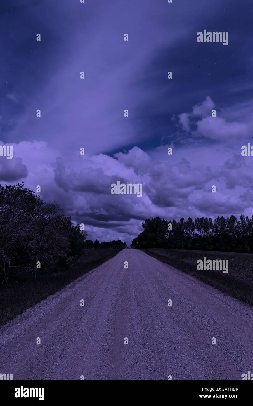 Strada sterrata rurale solitaria di notte durante una luna piena Foto Stock