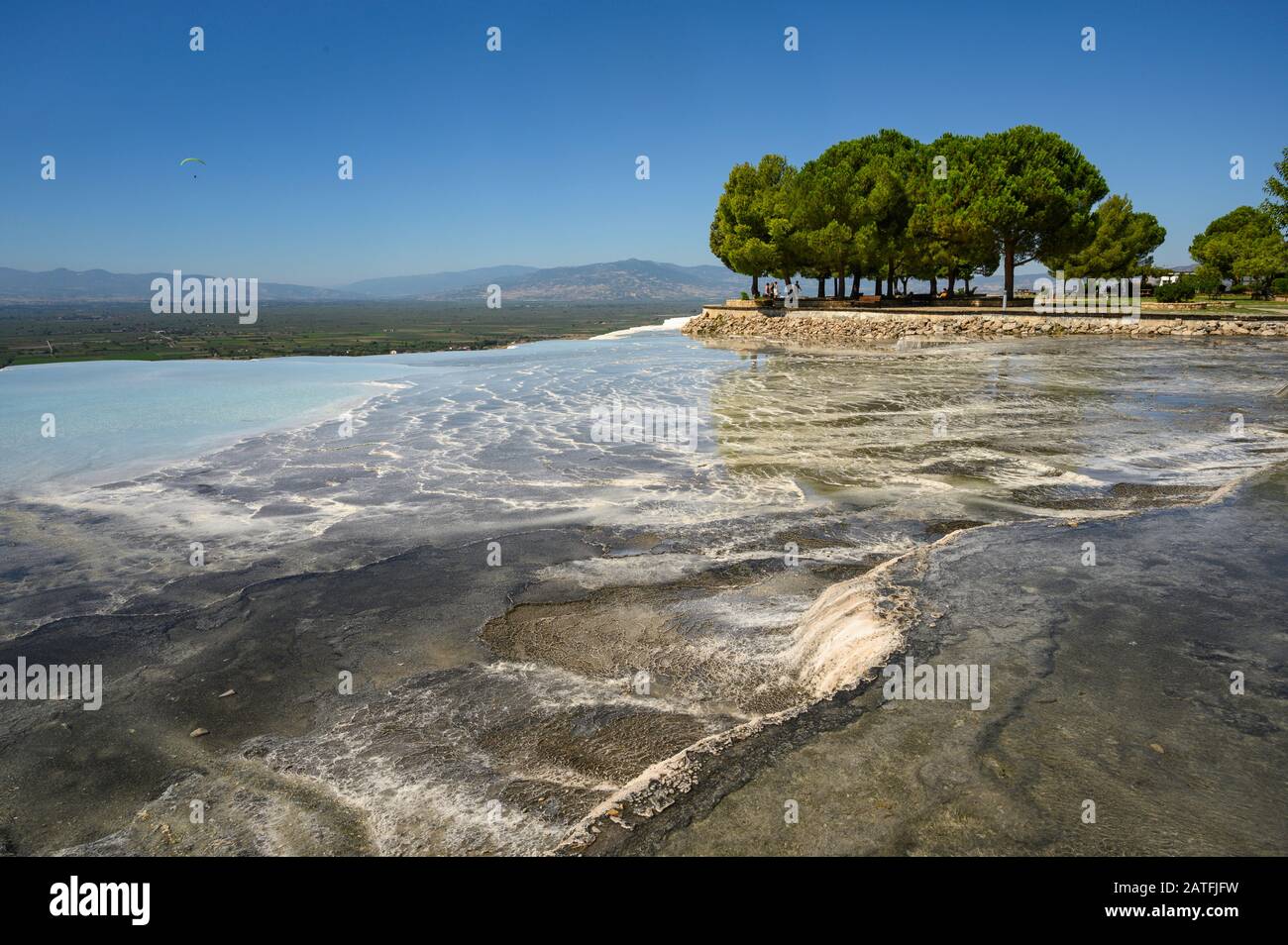 Acque termali ricche di minerali che scorrono lungo terrazze di travertino a Pamukkale, Turchia Foto Stock