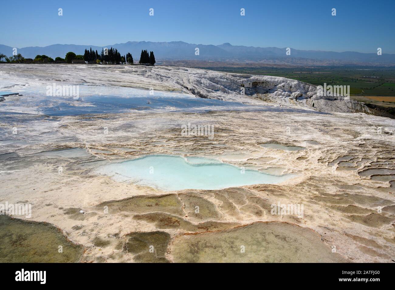 Acque termali ricche di minerali che scorrono lungo terrazze di travertino a Pamukkale, Turchia Foto Stock