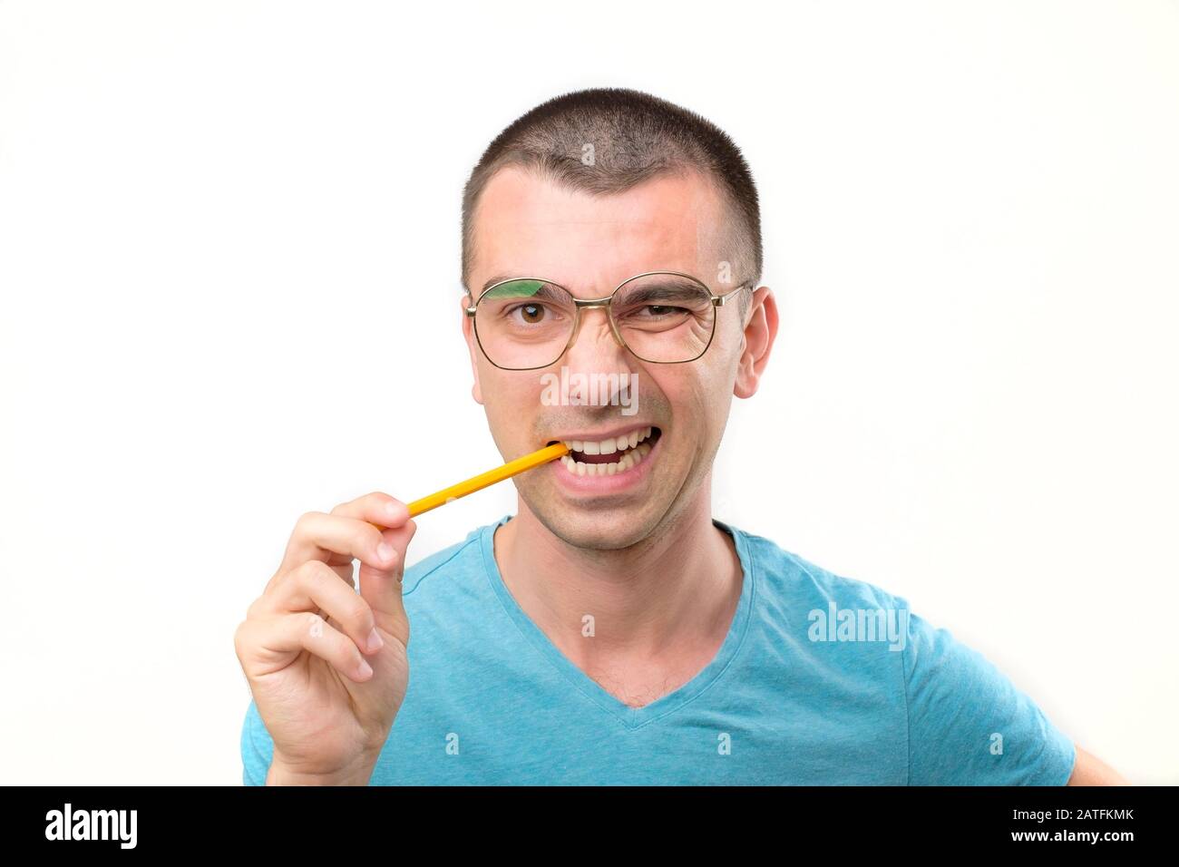 Il giovane uomo ispanico negli occhiali sta pensando a qualcosa con la matita che genera l'idea. Studio Foto Stock