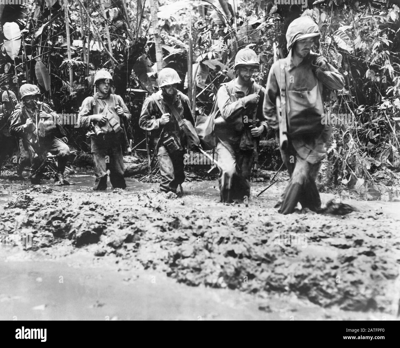I Marines degli Stati Uniti si muovono e passano attraverso il fango sulla loro strada alle linee anteriori sull'isola di Bougainville, novembre 1943 Foto Stock