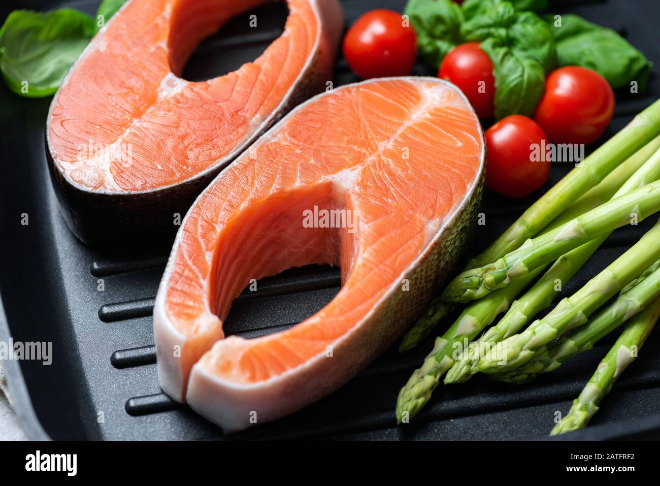 Bistecche di salmone crudo crudo crudo e verdure in padella grill vista closeup. Cibo sano Foto Stock