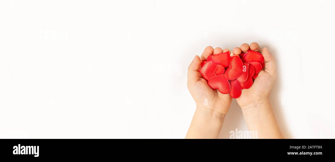 Close up bambino mani hearton rosso sfondo bianco - la gente, di amore, di carità e di concetto di famiglia Foto Stock