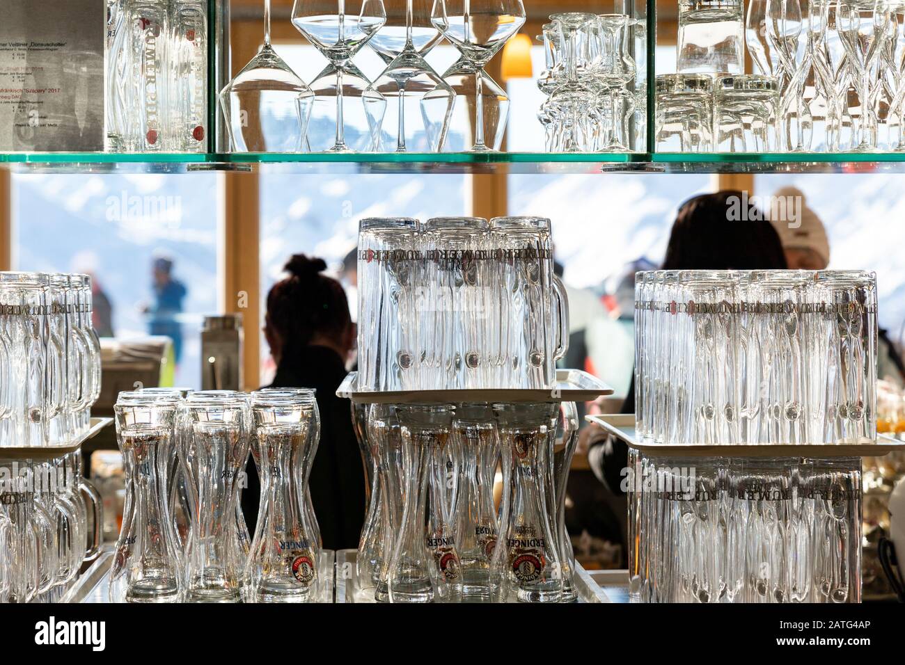 Ischgl,Austria - Gennaio 10th, 2020: Parete di molti bicchieri vuoti di vino e birra trasparente su ripiano di vetro al ristorante di montagna nella zona di Idalp Foto Stock