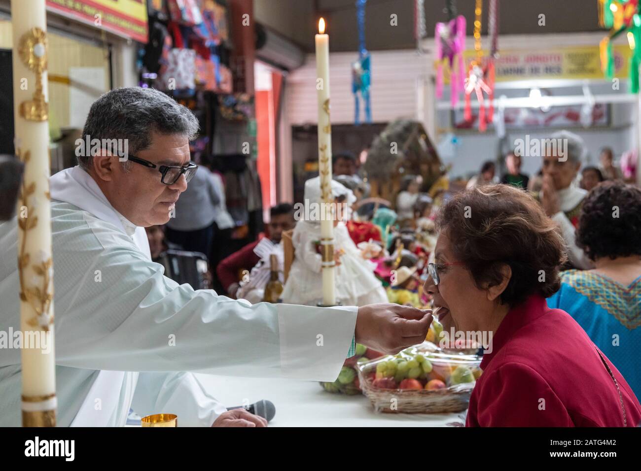 Oaxaca De Juarez, Messico. 2nd Feb, 2020. Fr. Hector Zavala Balboa fa la comunione durante la messa al mercato di Sanchez Pascuas sul DIA de la Candelaria. L'evento celebra 40 giorni dopo la nascita di Gesù. Le famiglie vestono le bambole del Gesù Bambino e le prendono alla messa per essere benedette. Credito: Jim West/Alamy Live News Foto Stock