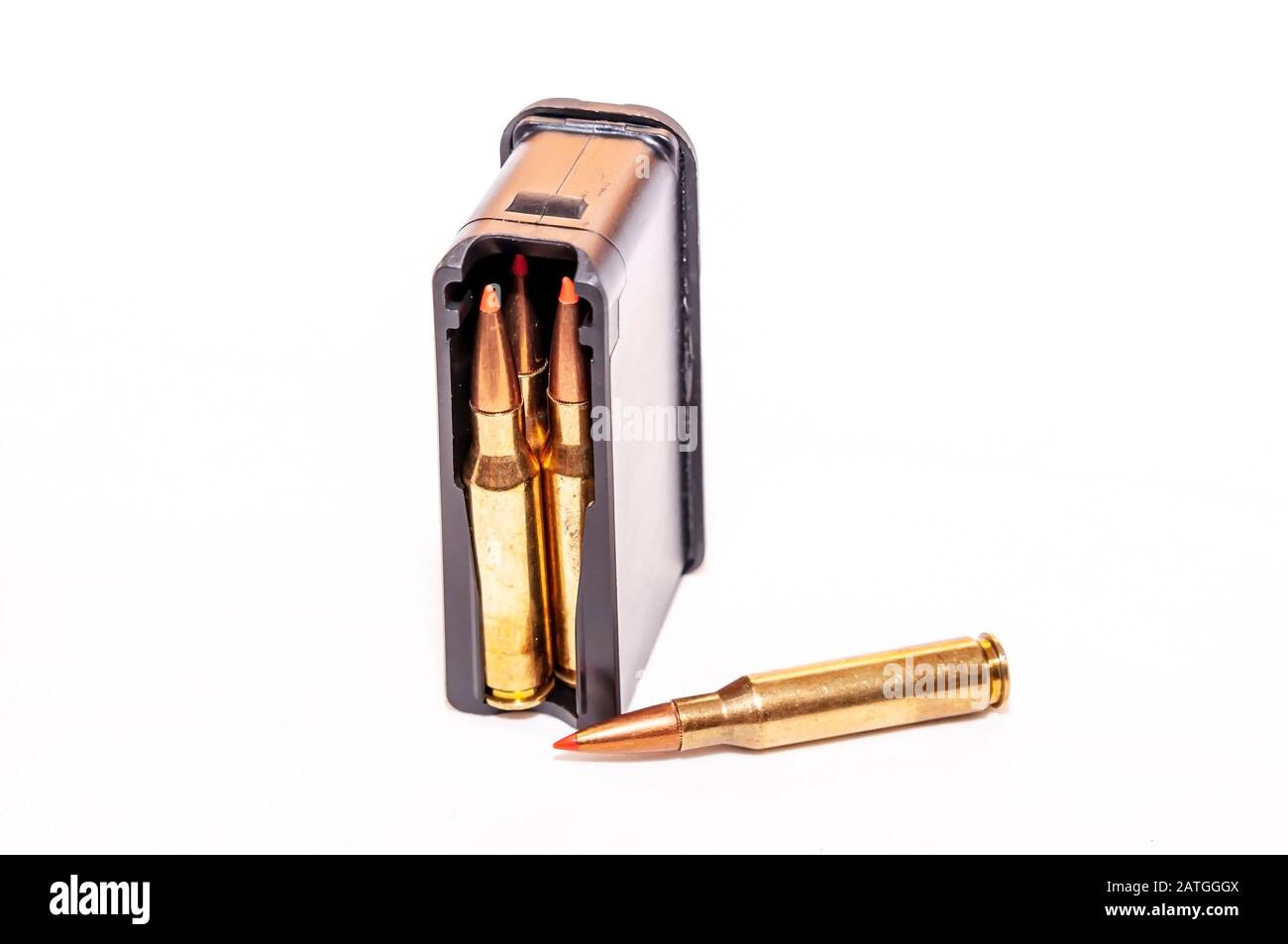 Una rivista di fucili carica di munizioni con un unico proiettile con punta rossa accanto ad essa su sfondo bianco Foto Stock