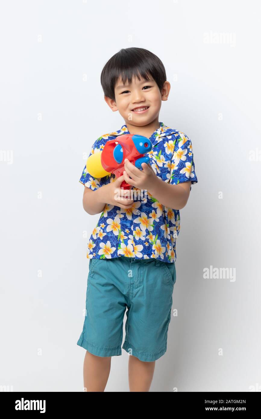 Benvenuti Thailandia Songkran festival, Ritratto di ragazzo asiatico indossando flower shirt sorrise con pistola ad acqua su sfondo bianco. Foto Stock