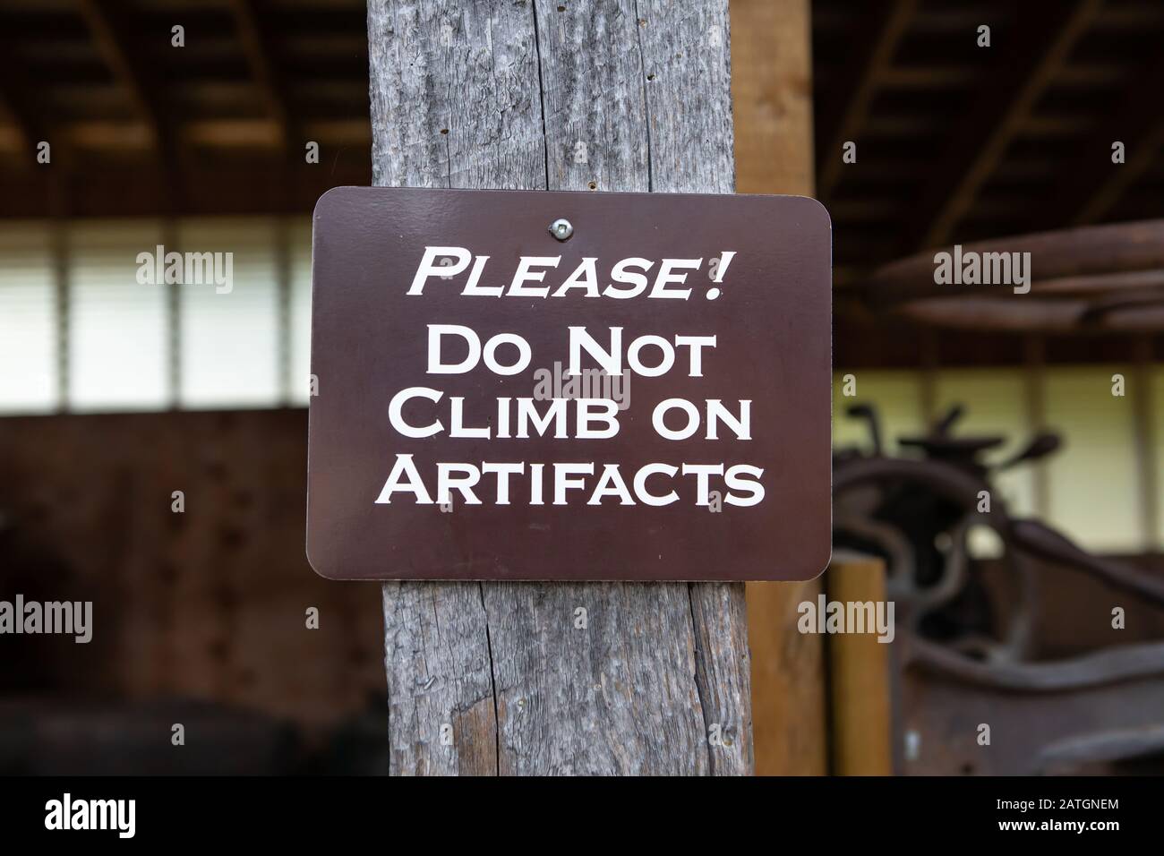 Cartello con messaggio di attenzione. Non salire sugli artefatti. Un cartello in legno impiccato nel museo, Kootenays, British Columbia, Canada Foto Stock