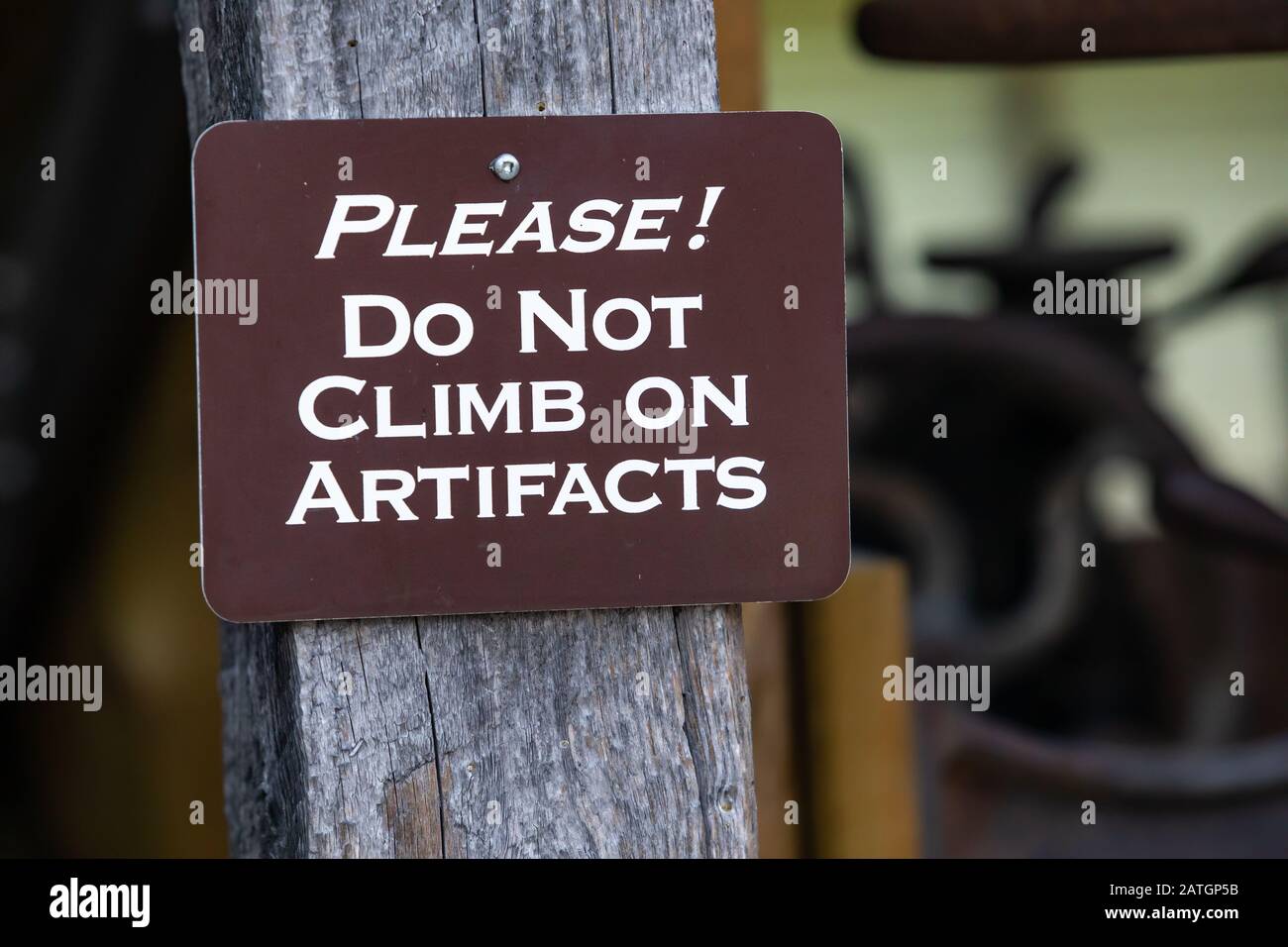 Un cartello in legno con testo - non salire su manufatti impiccati nel museo, Kootenays, British Columbia, Canada Foto Stock