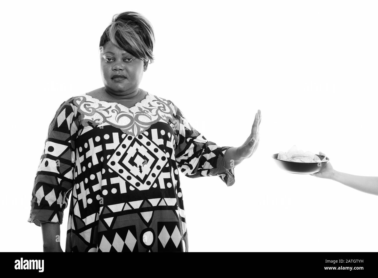 Studio colpo di grasso nero donna africana che rifiuta ciotola di patatine fritte Foto Stock
