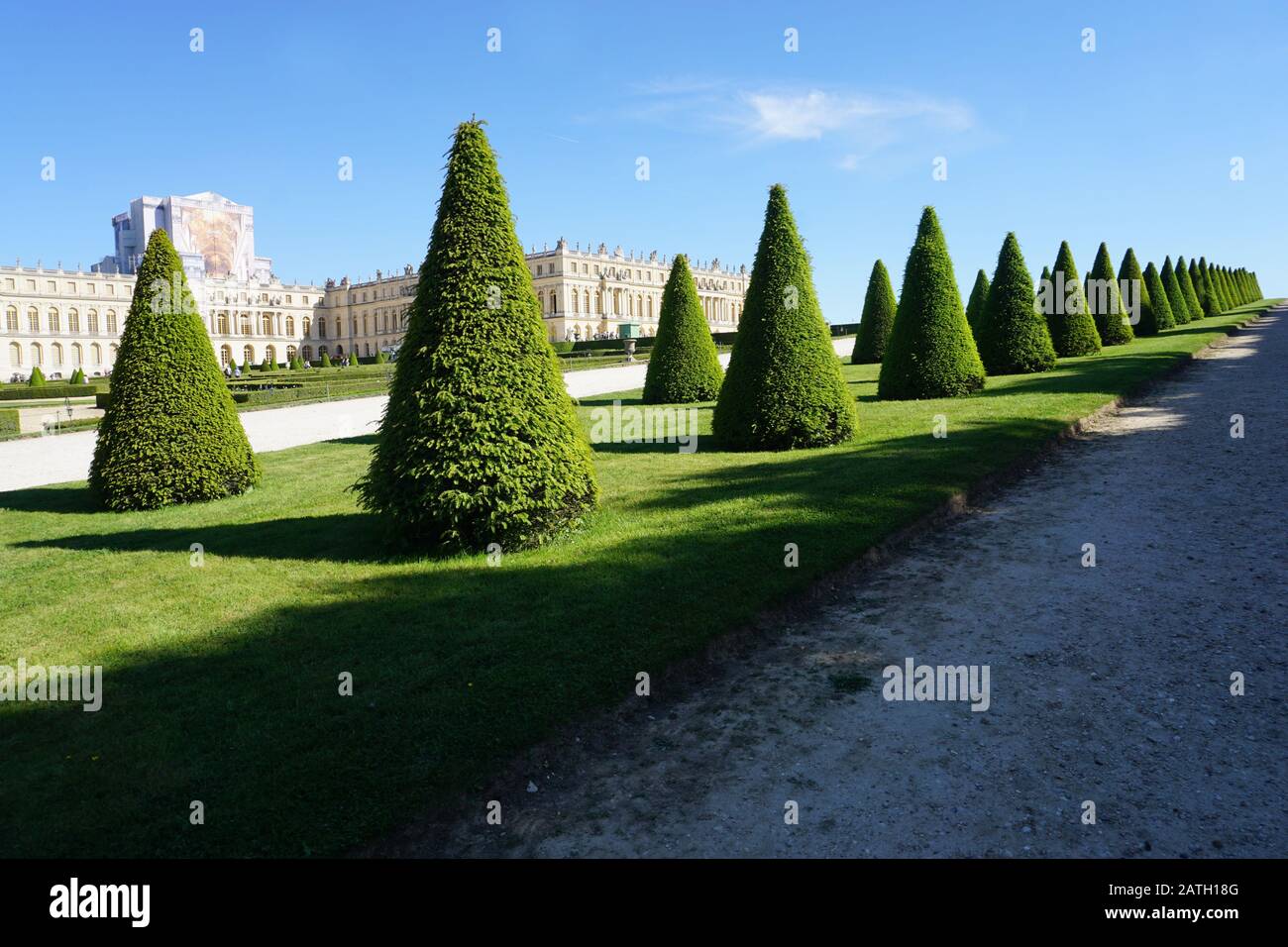 Vista sui giardini su misura e l'edificio del castello di Versailles, Francia, in una giornata di sole Foto Stock