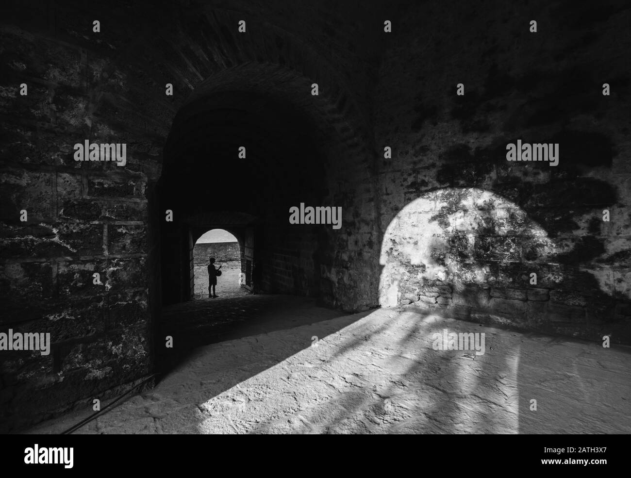 Diu, India - Dicembre 2018: Un'immagine in scala di grigi della luce che cade sulle pareti attraverso gli archi geometrici dell'antico forte Diu costruito in Portogallo Foto Stock