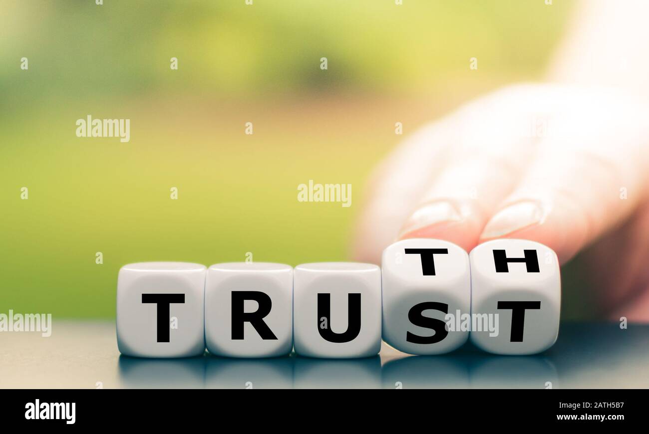 Verità invece di fiducia. Mano gira dadi e cambia la parola "fiducia" in "verità". Foto Stock