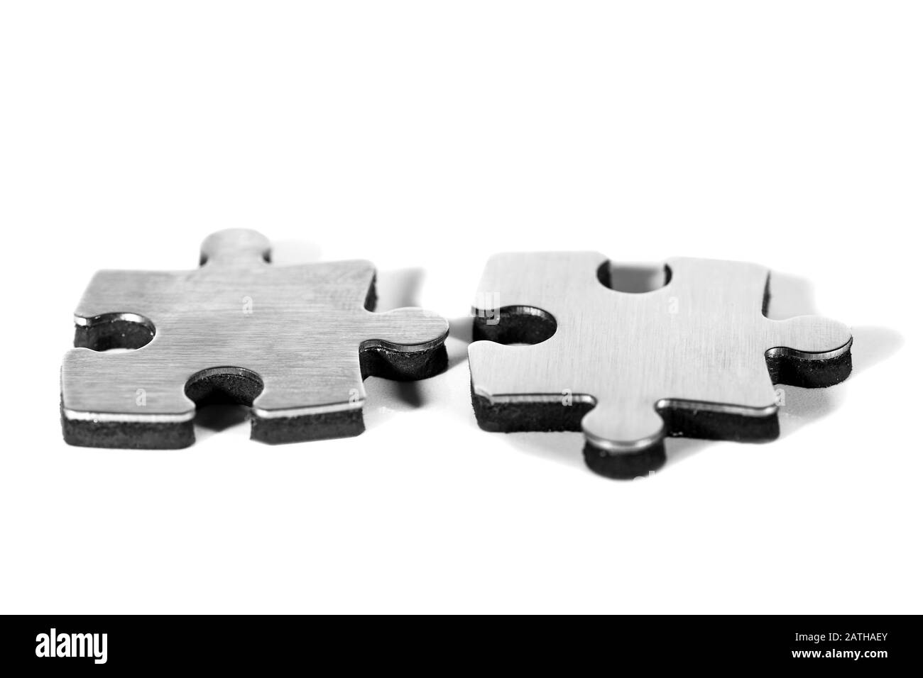 Due pezzi di puzzle sono messi insieme, isolato su sfondo bianco Foto Stock