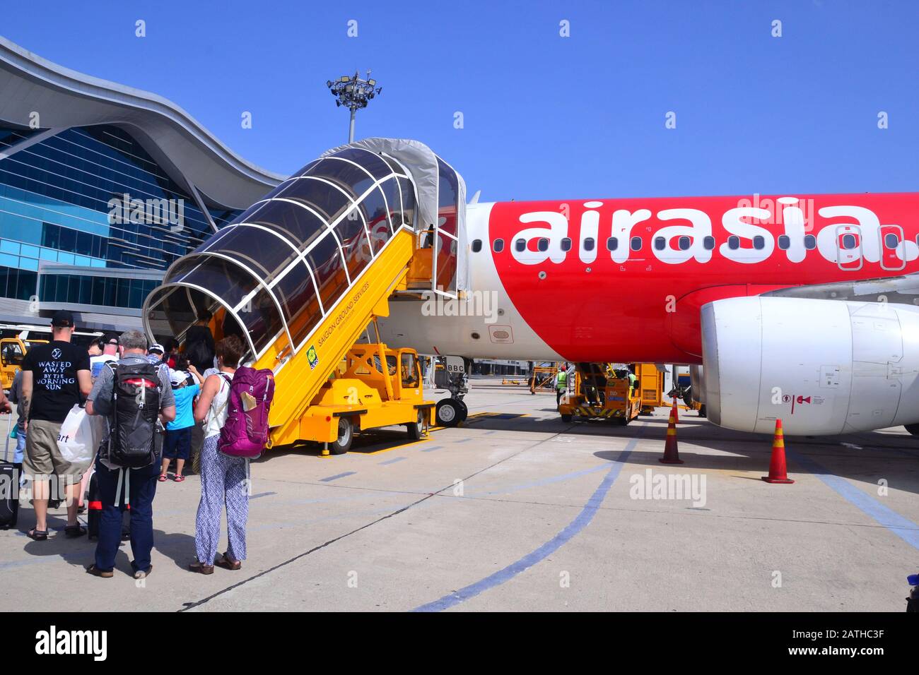 I passeggeri, compresi i turisti, salgo su gradini mobili per salire a bordo di un aereo Air Asia all'aeroporto Internazionale Cam Ranh, Vietnam, Asia Foto Stock