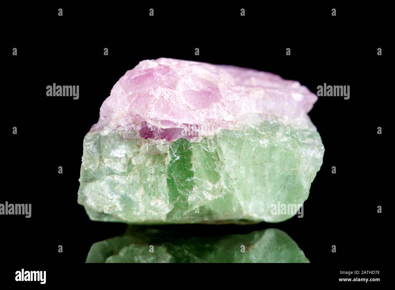 Pietra minerale verde crudo e tormalina rosa di fronte a sfondo nero, mineralogia e esoterismo Foto Stock