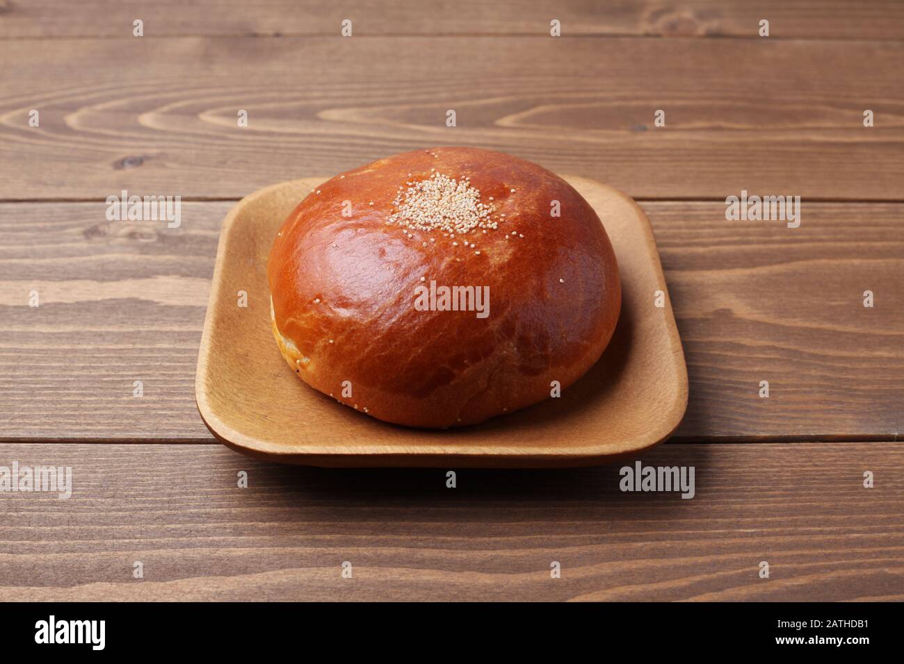 pane rotondo anpan con pasta di fagioli rossi azuki isolato su piatto su tavola di legno Foto Stock