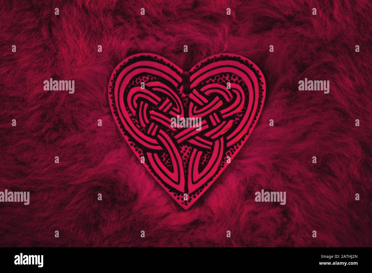Cuore di San Valentino, simbolo di amore e amicizia. Il cuore celtico si trova su un tappeto di pelliccia Foto Stock