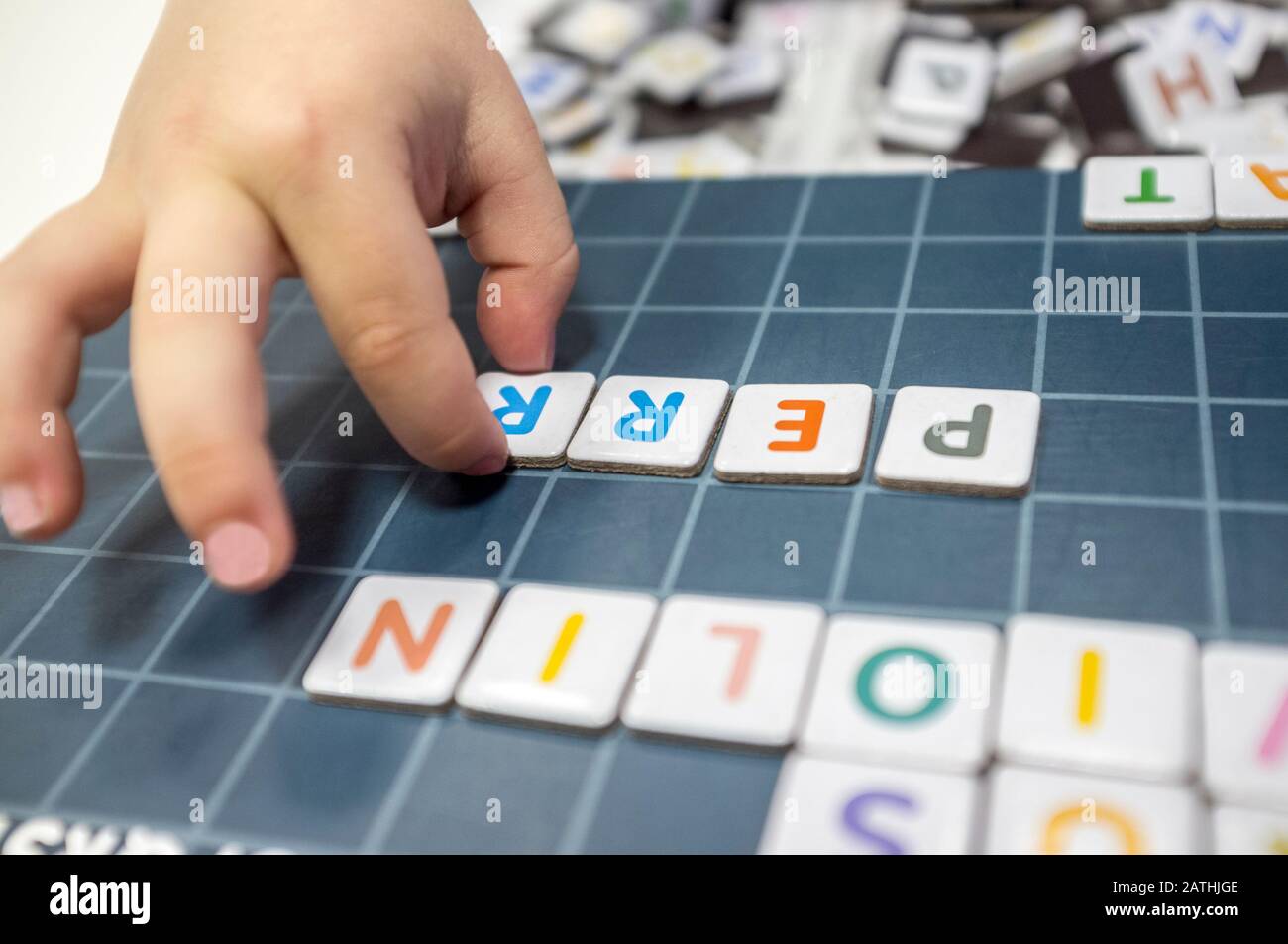 Pratiche del bambino con il gioco del bordo di formazione di parola. Il gioco è fatto con pezzi di lettera magnetica. Messa a fuoco selettiva Foto Stock