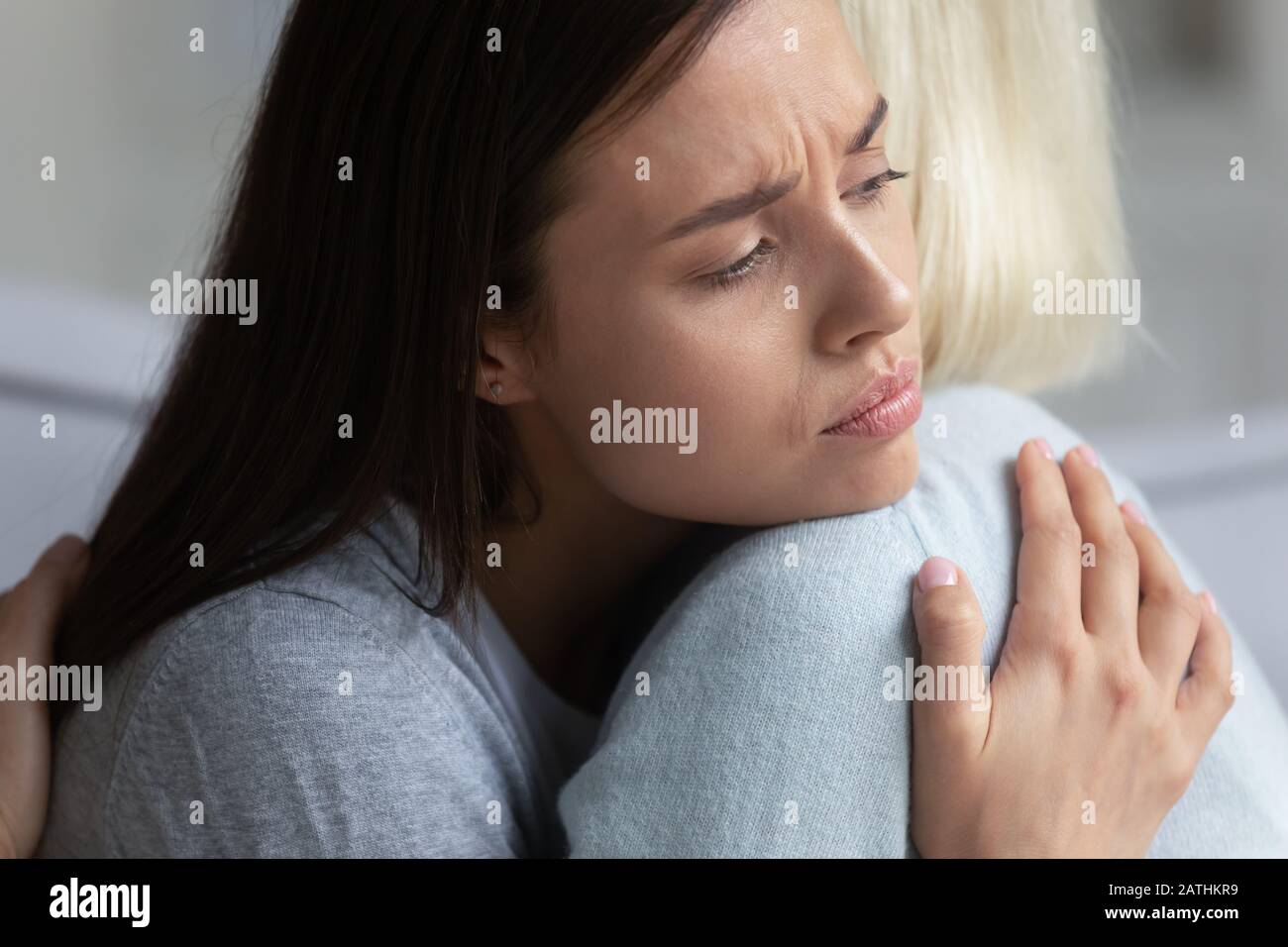 Mamma e figlia adulta sconvolti abbracciano mostrando supporto e cura Foto Stock