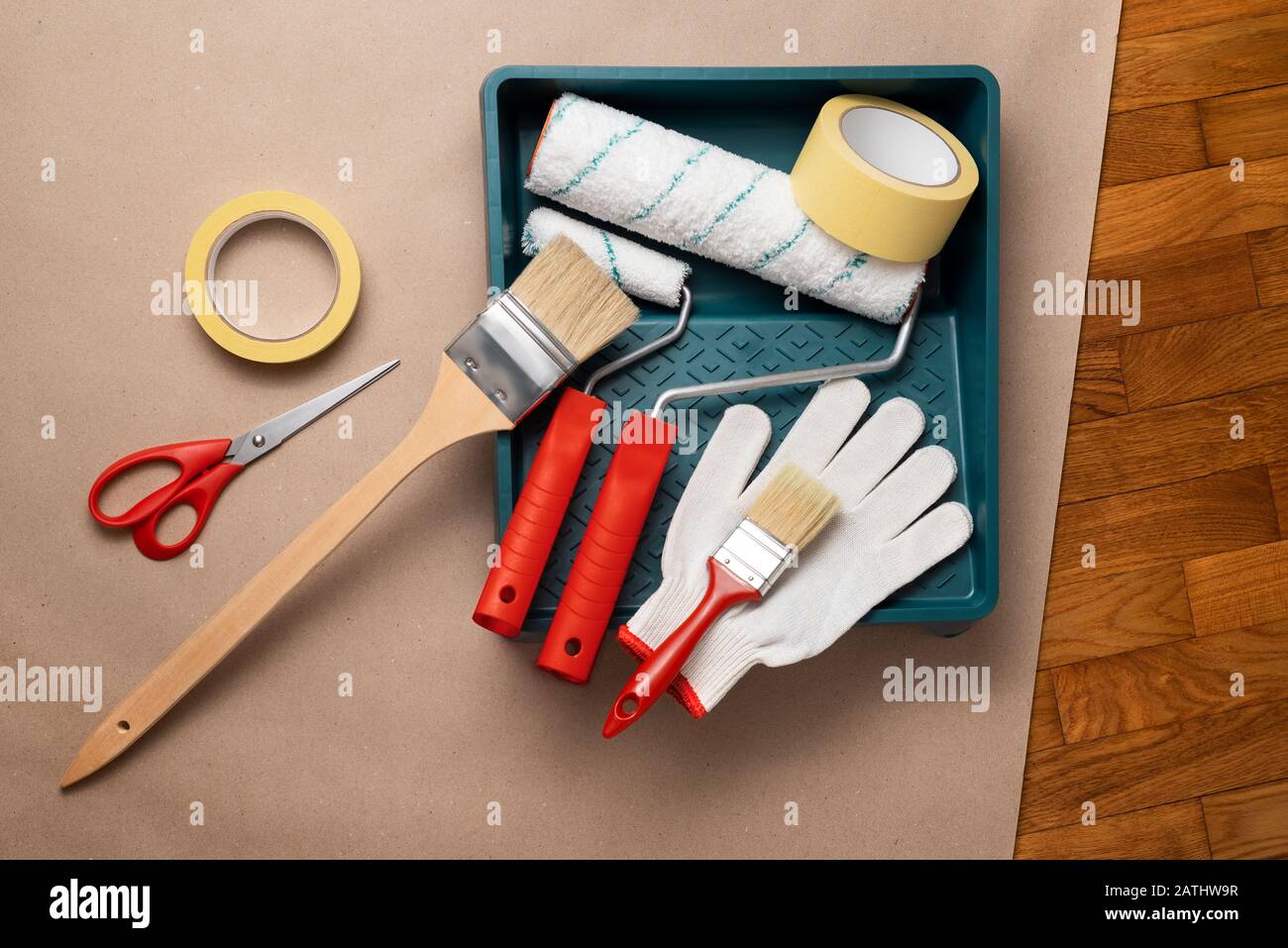 Attrezzi necessari per verniciare una parete: Rulli di vernice e vassoio, spazzola e spazzola di vernice a manico lungo, nastro di mascheratura, guanti, forbici Foto Stock