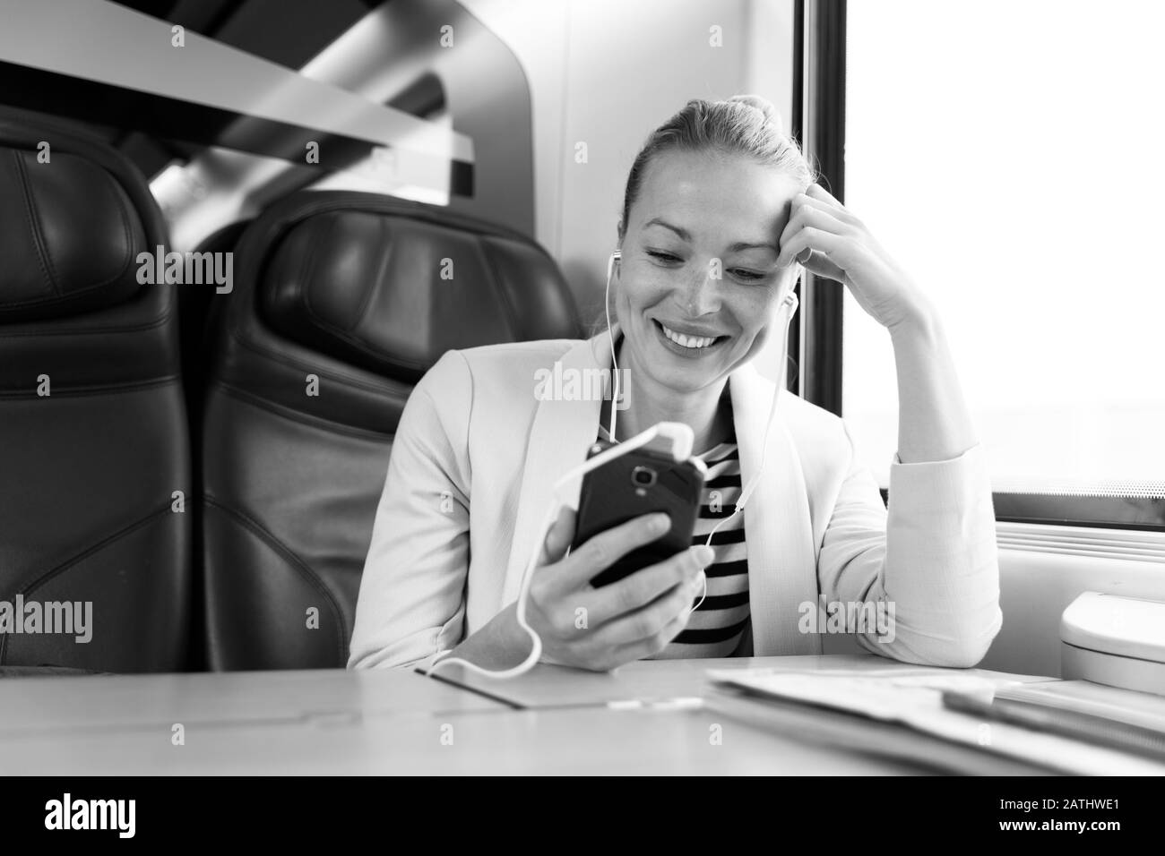 Imprenditrice comunicanti sul telefono cellulare mentre si è in viaggio in treno. Foto Stock