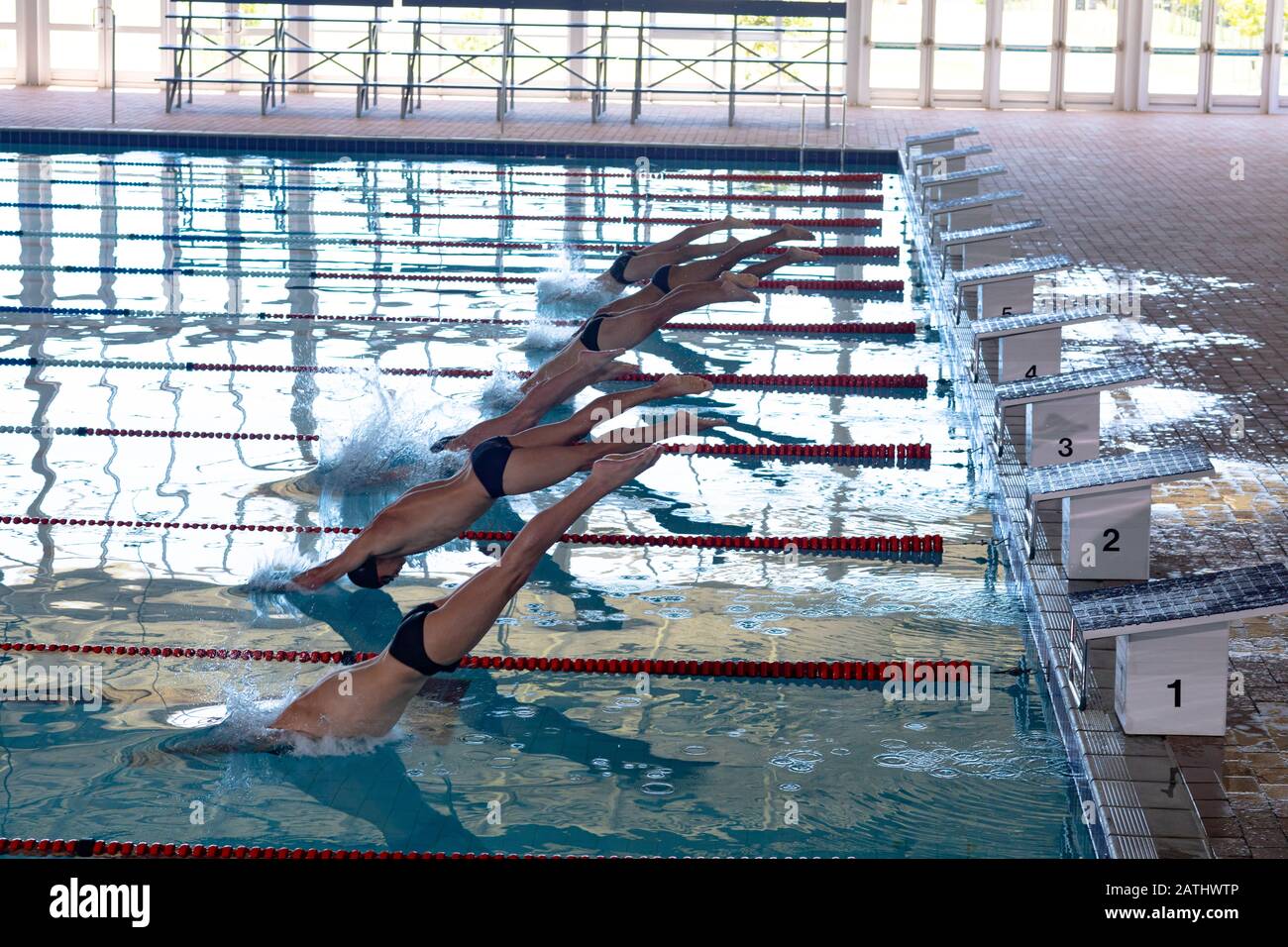 Nuotatori che si tuffano in piscina Foto Stock