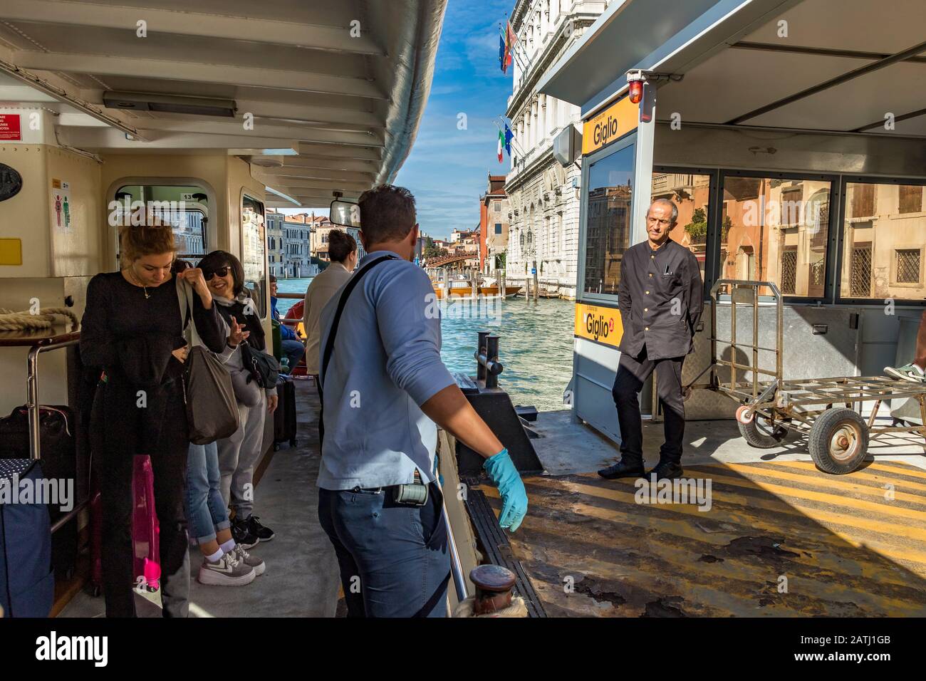 Un vaporetto o un operatore Vaporetto che apre il cancello per permettere ai passeggeri di scendere alla stazione Giglio Vaporetto, Venezia, Italia Foto Stock