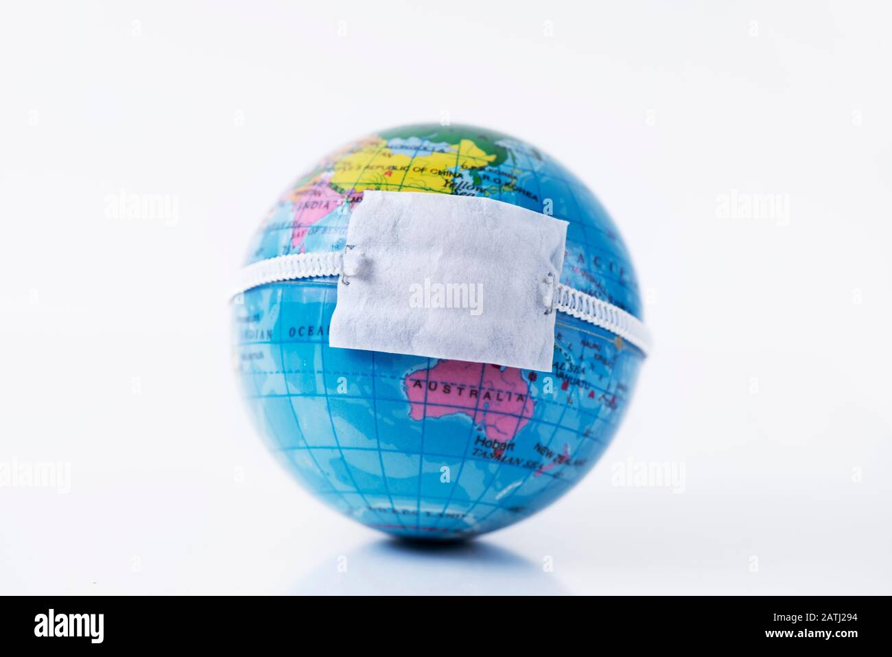 Primo piano di un globo terrestre con una maschera protettiva posta sopra la Cina, raffigurante la recente epidemia di coronavirus o la protezione contro l'aria p Foto Stock