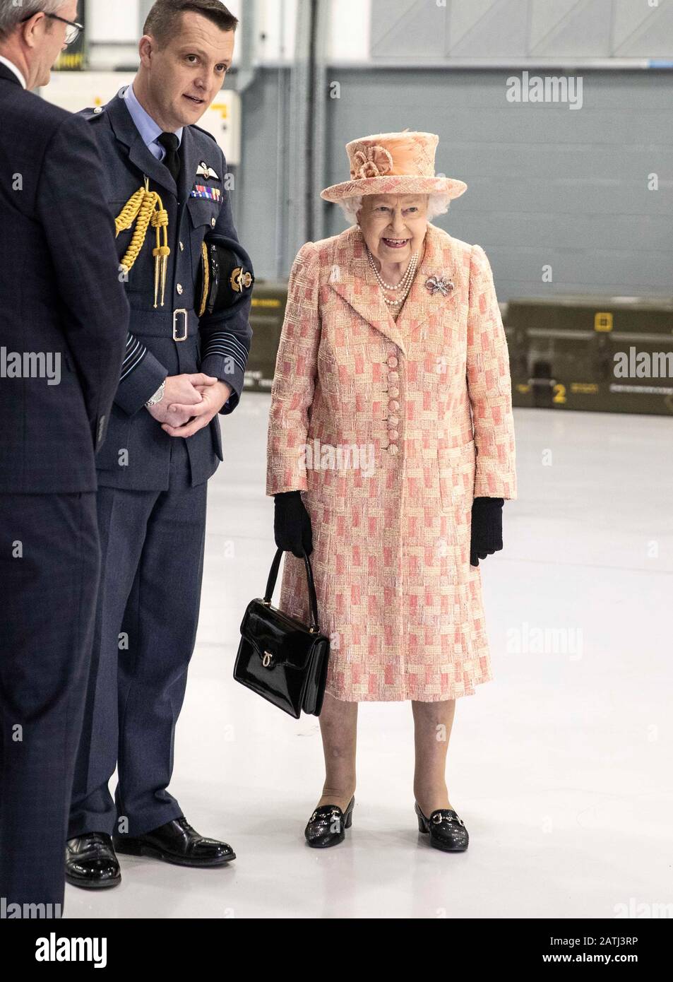 La regina Elisabetta II, con il comandante della stazione James Beck (centro), guarda l'equipaggio al lavoro su un modello di addestramento F-35B Lightning II combattente durante una visita alla Royal Air Force Marham, Norfolk. Foto Stock