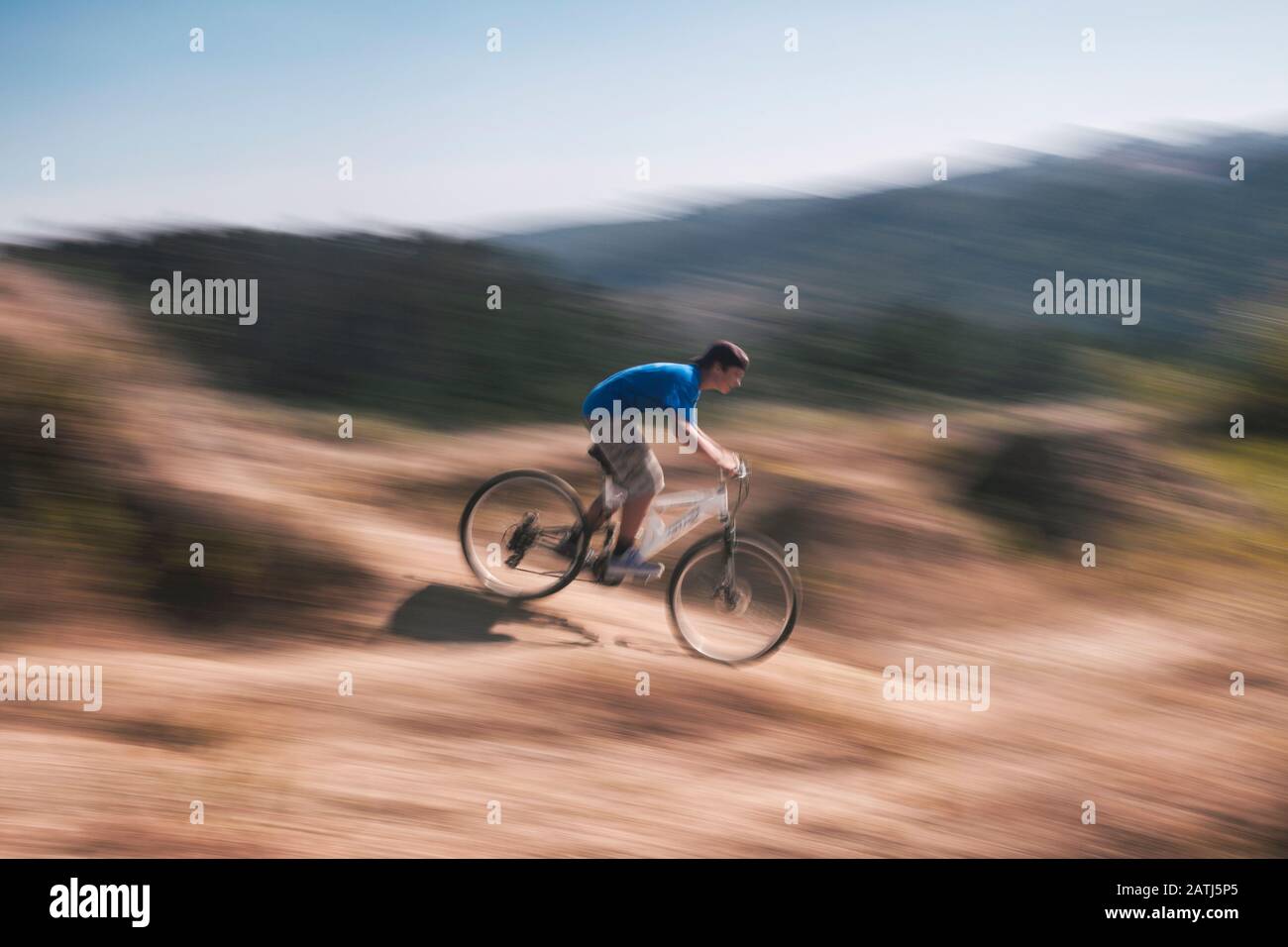 Immagine del movimento di un ragazzo che guida una bicicletta fuoristrada su un terreno accidentato Foto Stock