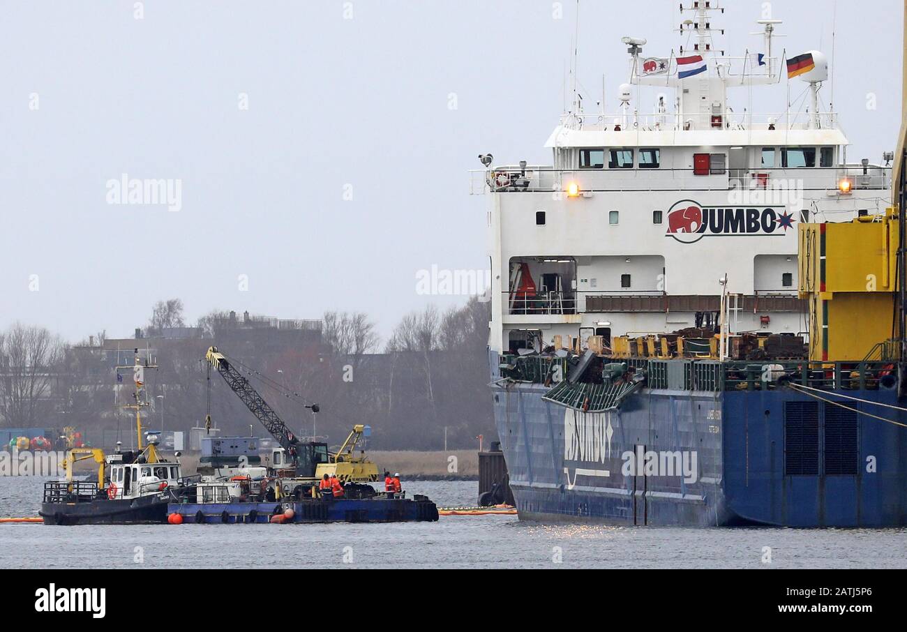 Rostock, Germania. 03rd Feb, 2020. Oltre a un'imbarcazione da lavoro, il porto marittimo ospita la nave da carico pesante con bandiera olandese "Jumbo Vision" (r), da cui due gru portuali mobili sono cadute nel bacino del porto in un incidente del 31.01.2020 durante il caricamento. Le gru costano tra i tre e i cinque milioni di euro - a seconda delle loro attrezzature -, pesano circa 440 tonnellate ciascuna e hanno una portata fino a 54 metri. Attualmente è in corso la lavorazione di un concetto di recupero, ma non è ancora stata fissata una data di sollevamento del calcestruzzo. Credito: Bernd Wüstneck/Dpa-Zentralbild/Dpa/Alamy Live News Foto Stock