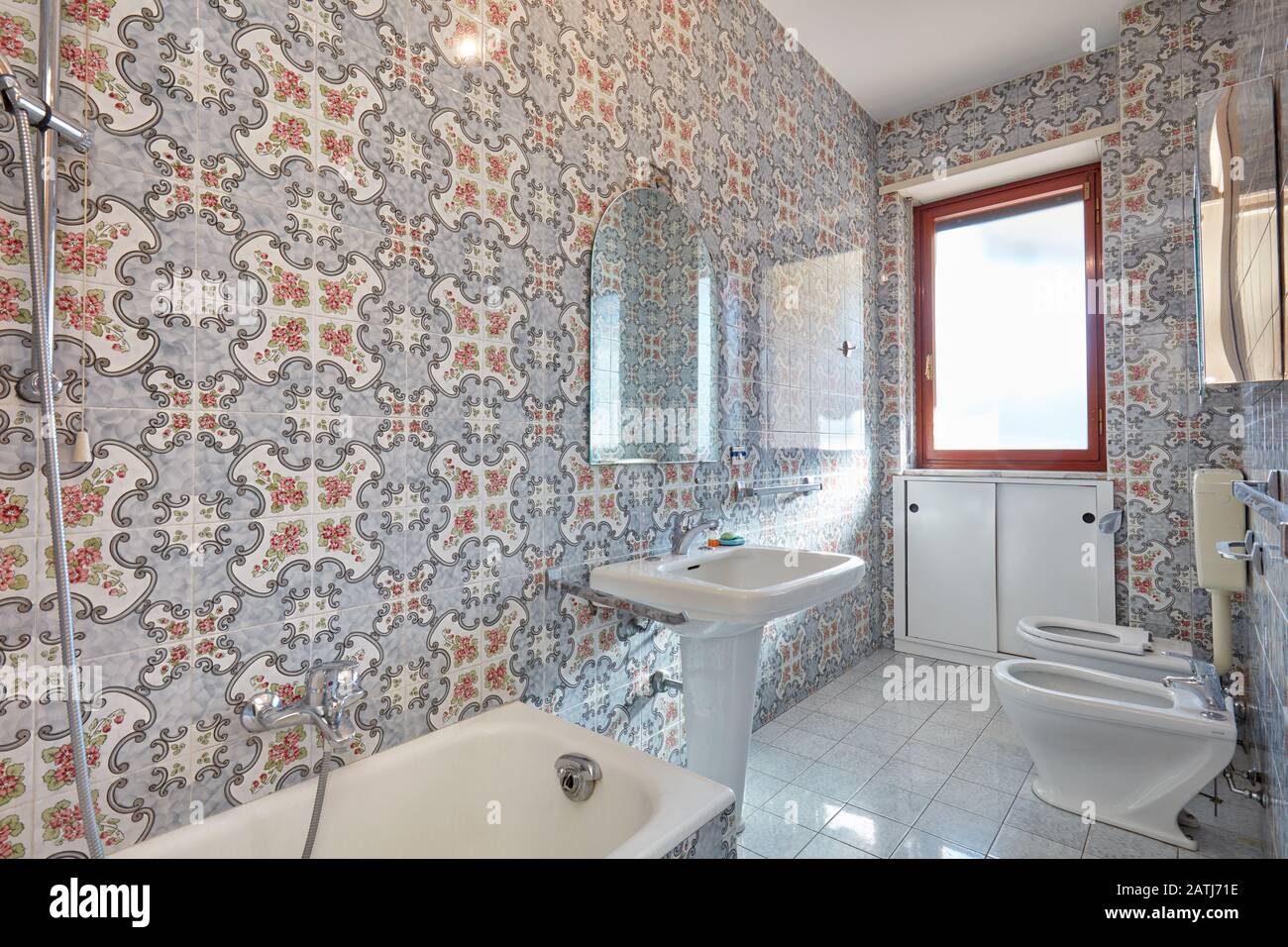 Interni bagno con piastrelle floreali, luce del sole Foto Stock