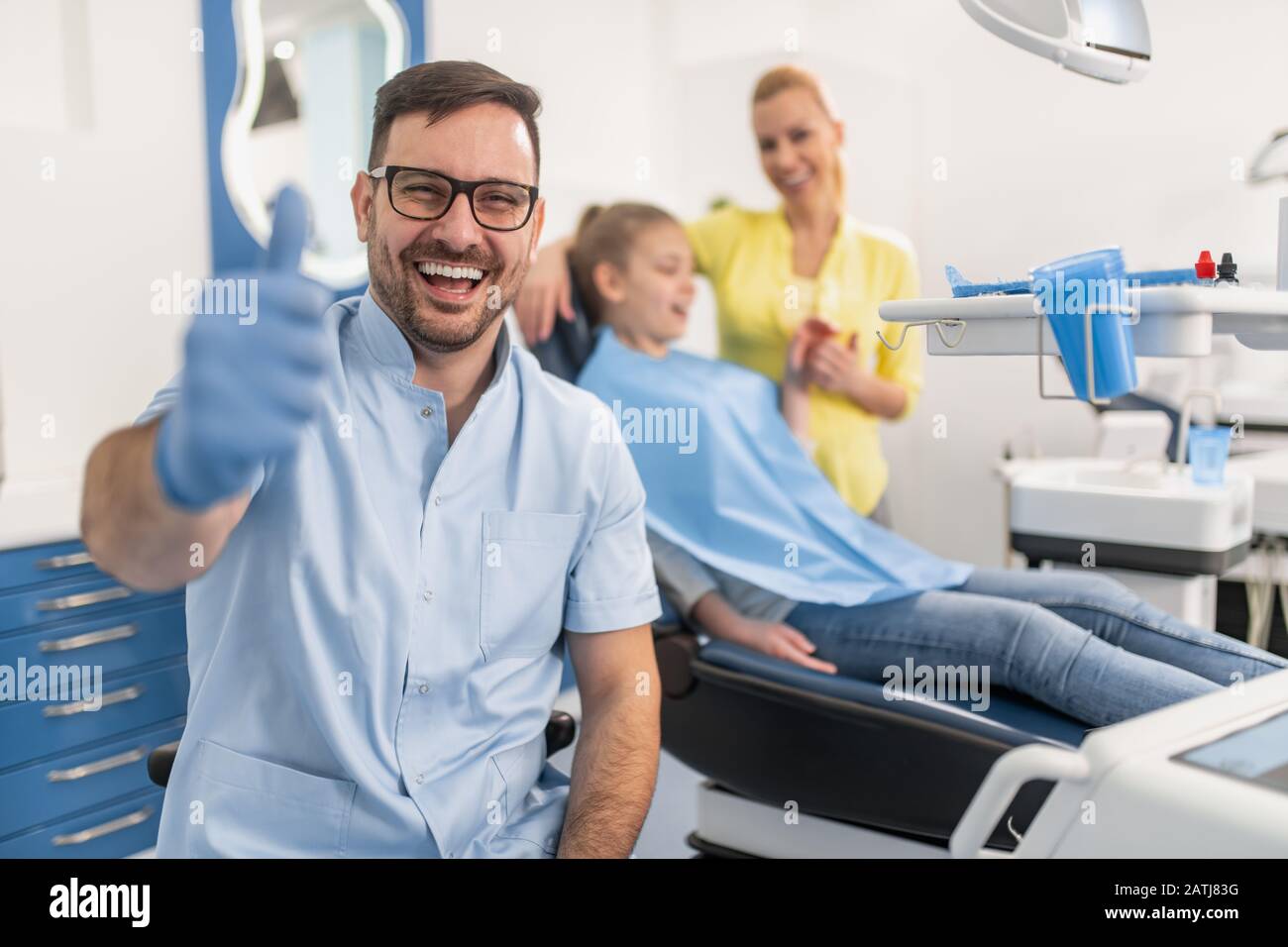 Il dentista dei bambini verifica i denti delle ragazze, mentre sedette sulla sedia dentale all'ufficio. Concetto di assistenza sanitaria. Foto Stock