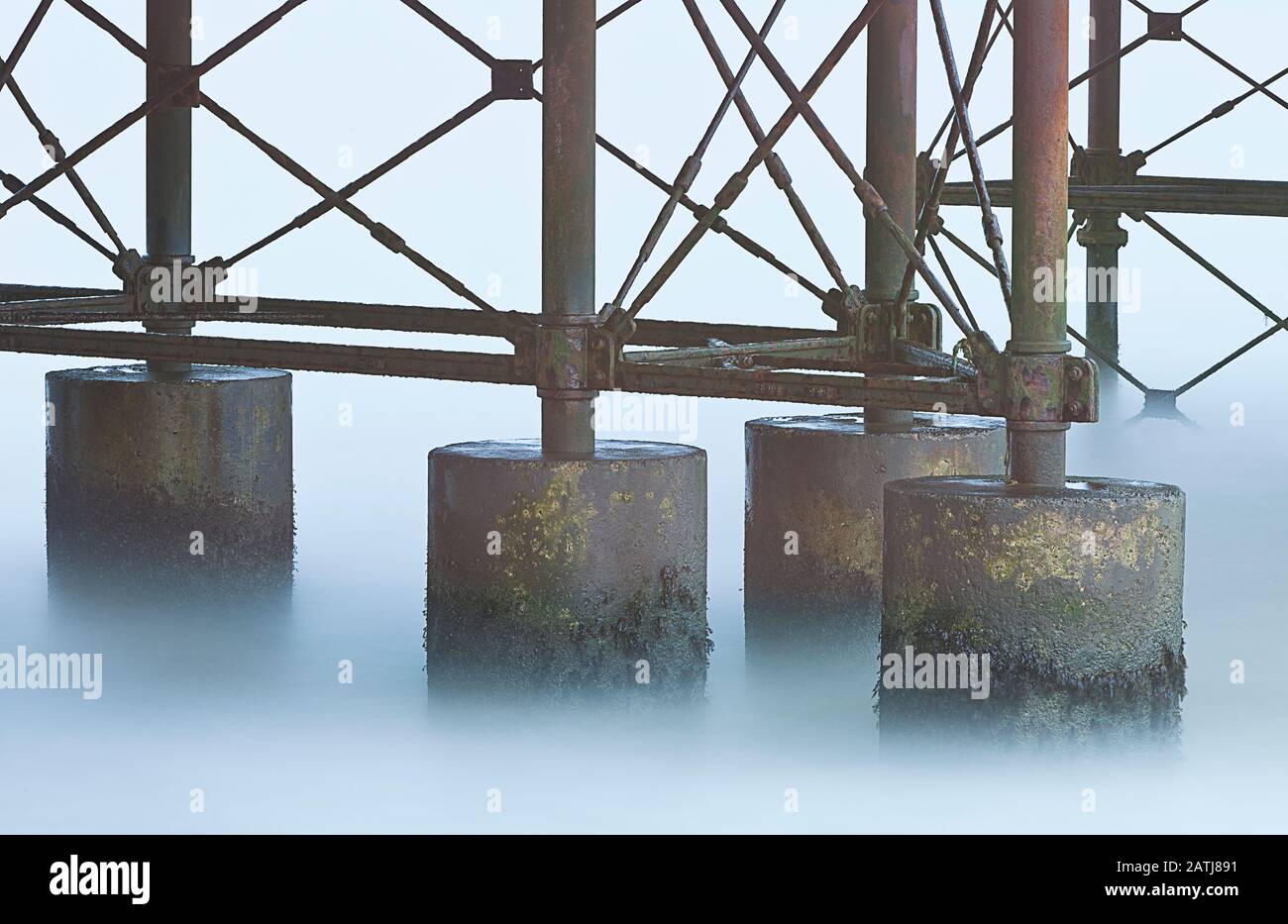 Onde che si fondono sotto il molo a Cromer in inverno a Norfolk Inghilterra Foto Stock