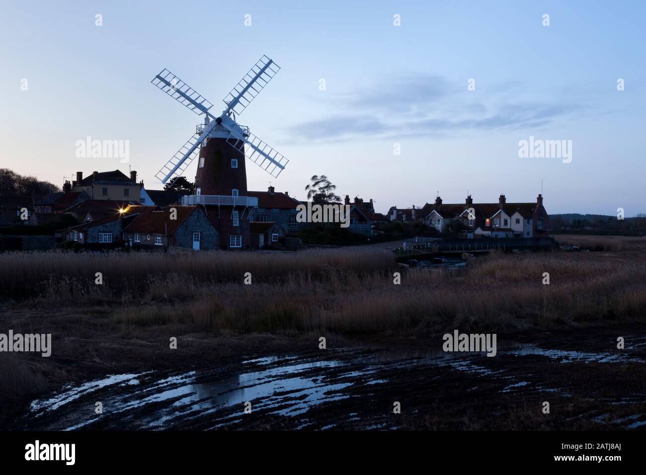Dawn a Cley Mill, sulla costa nord di Norfolk, in Inghilterra, nel Regno Unito, che mostra le tracce delle macchine di taglio reed Foto Stock