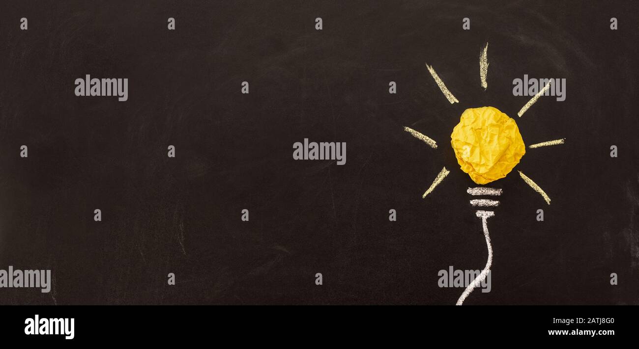 Nuova idea creativa. Innovazione, brainstorming, ispirazione e concetti di soluzione. Lampadina con carta sbriciolata su sfondo nero. Foto Stock