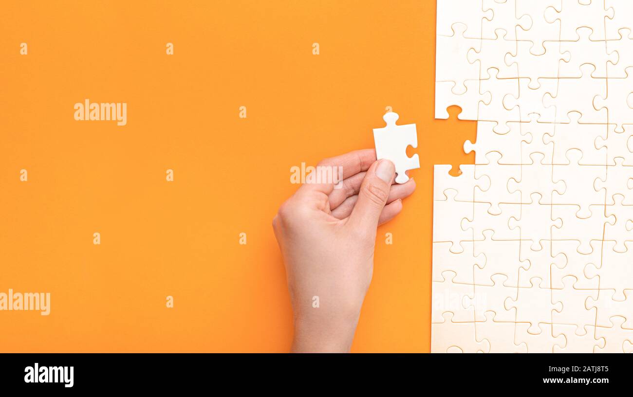 Mano mettere l'ultimo pezzo di puzzle. Completare la missione. Concetto di business. Foto Stock