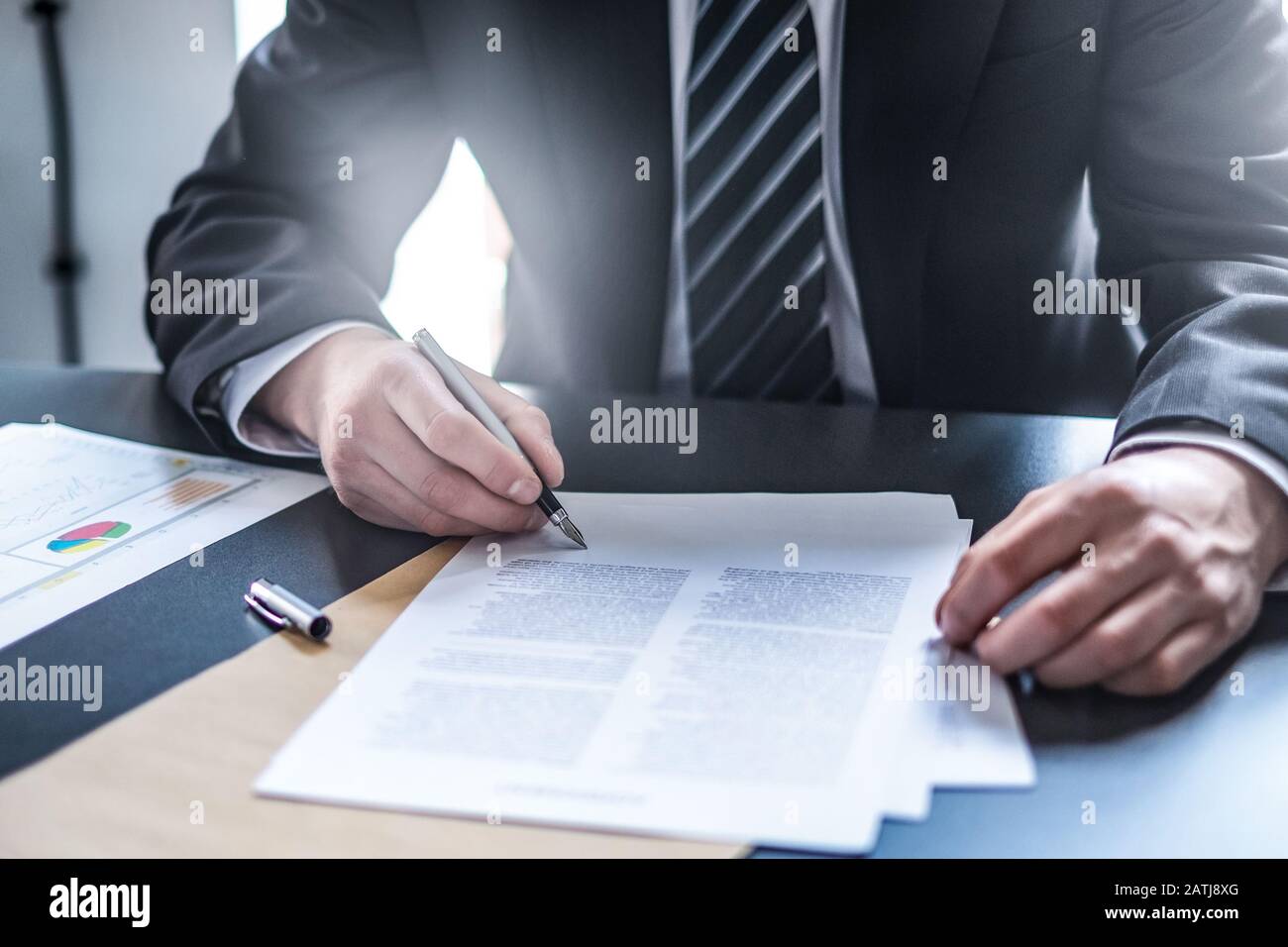 Uomo d'affari che firma il documento di contratto sulla scrivania dell'ufficio, facendo un affare. Foto Stock