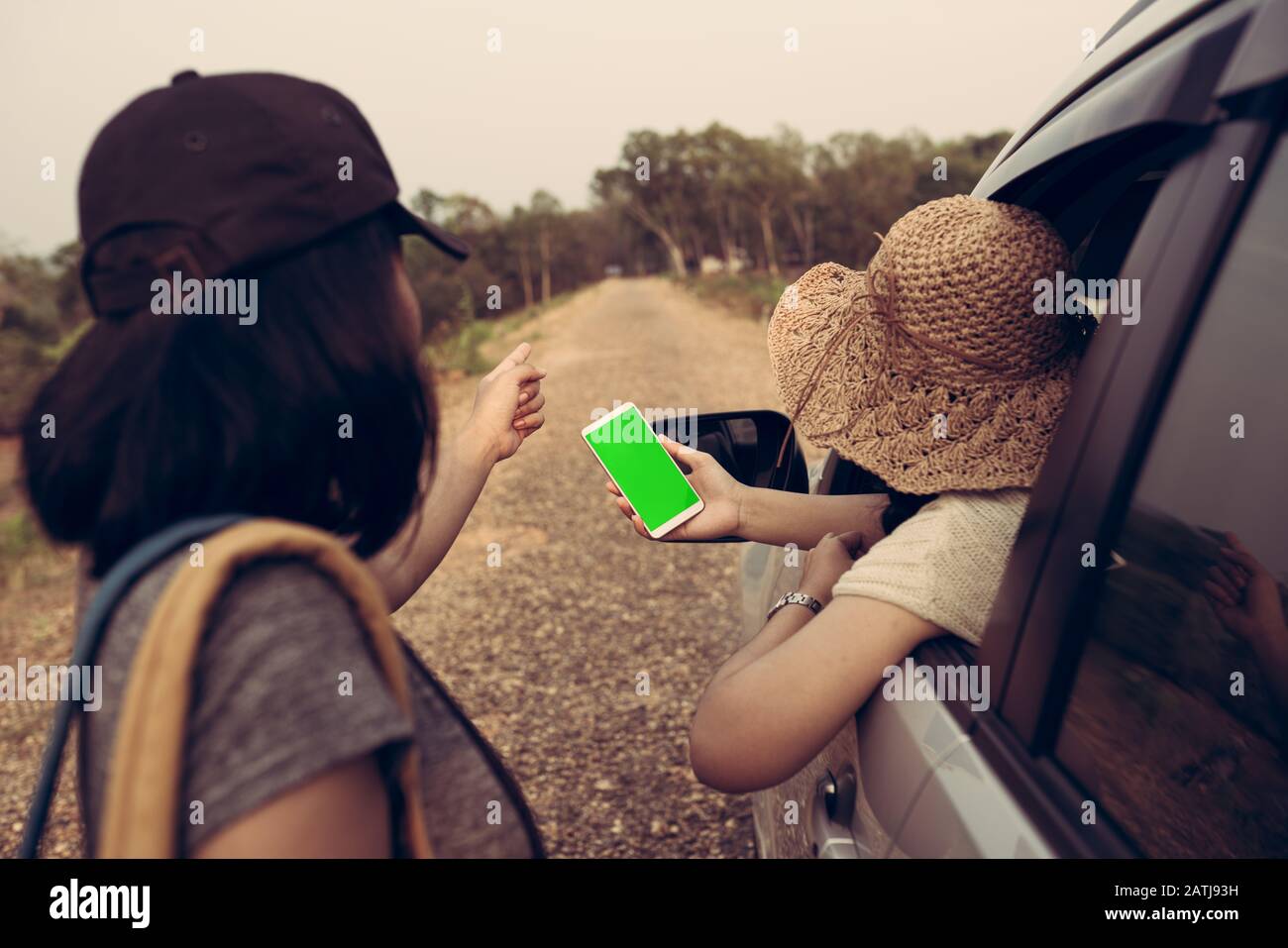 I viaggiatori che viaggiano in auto si stanno chiedendo indicazioni stradali utilizzando uno smartphone per guardare il GPS. Foto Stock