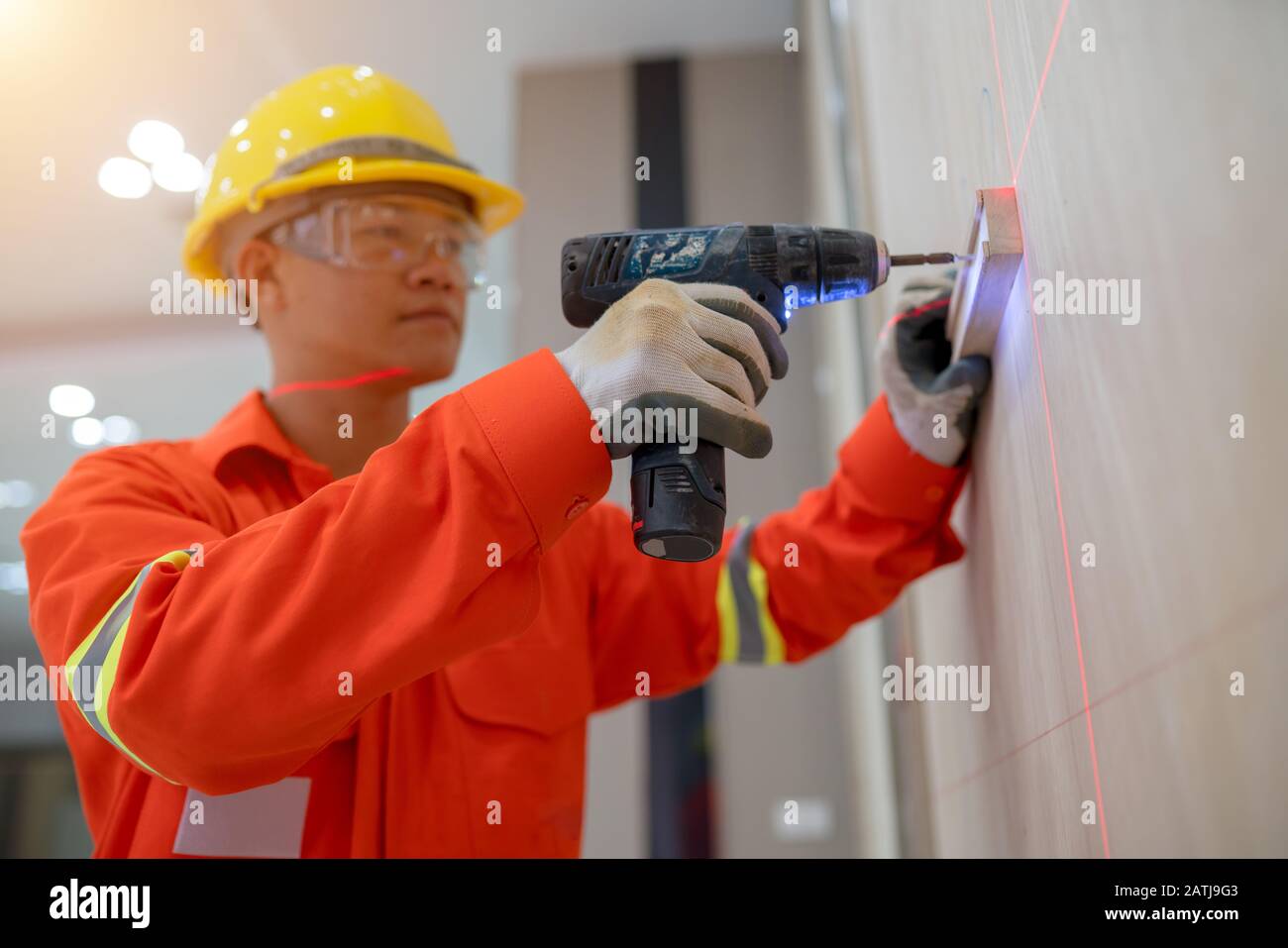 I tecnici stanno lavorando per penetrare la parete con un trapano elettrico. Foto Stock