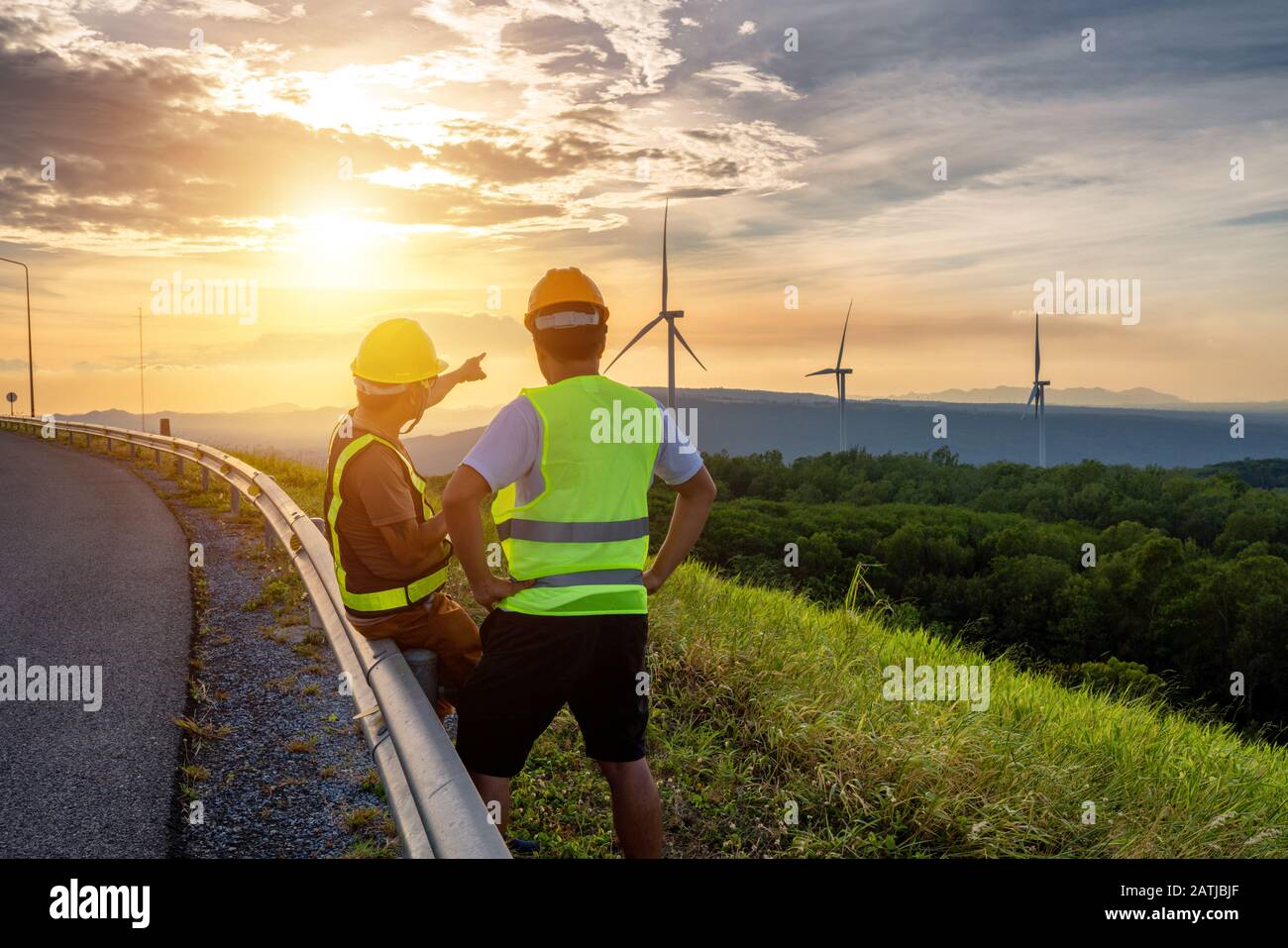 Due ingegneri si sono consultati per riparare e riparare le turbine eoliche per generare elettricità con energia naturale. Foto Stock