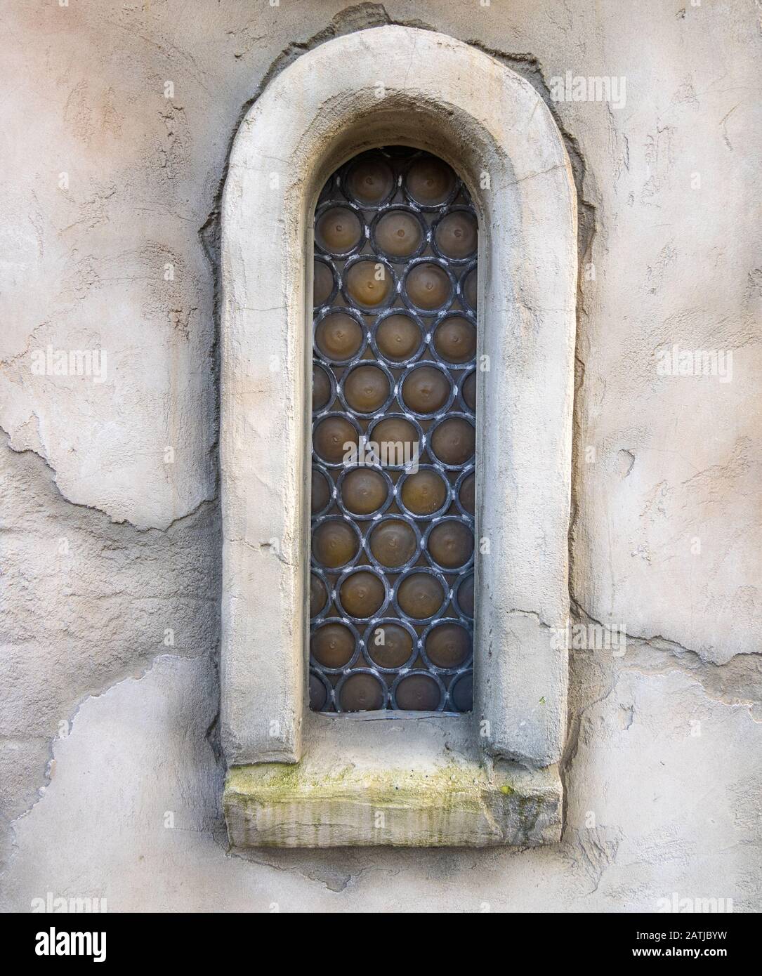 vista frontale di una vecchia finestra a tema fantasy. muro in pietra con mosaico in vetro Foto Stock