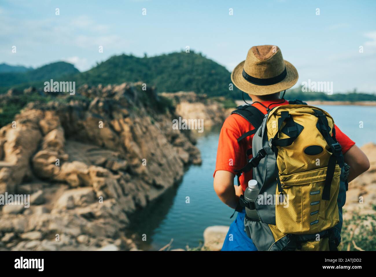 Giovane uomo backpacker in piedi al punto di riferimento che guarda la vista del paesaggio Foto Stock