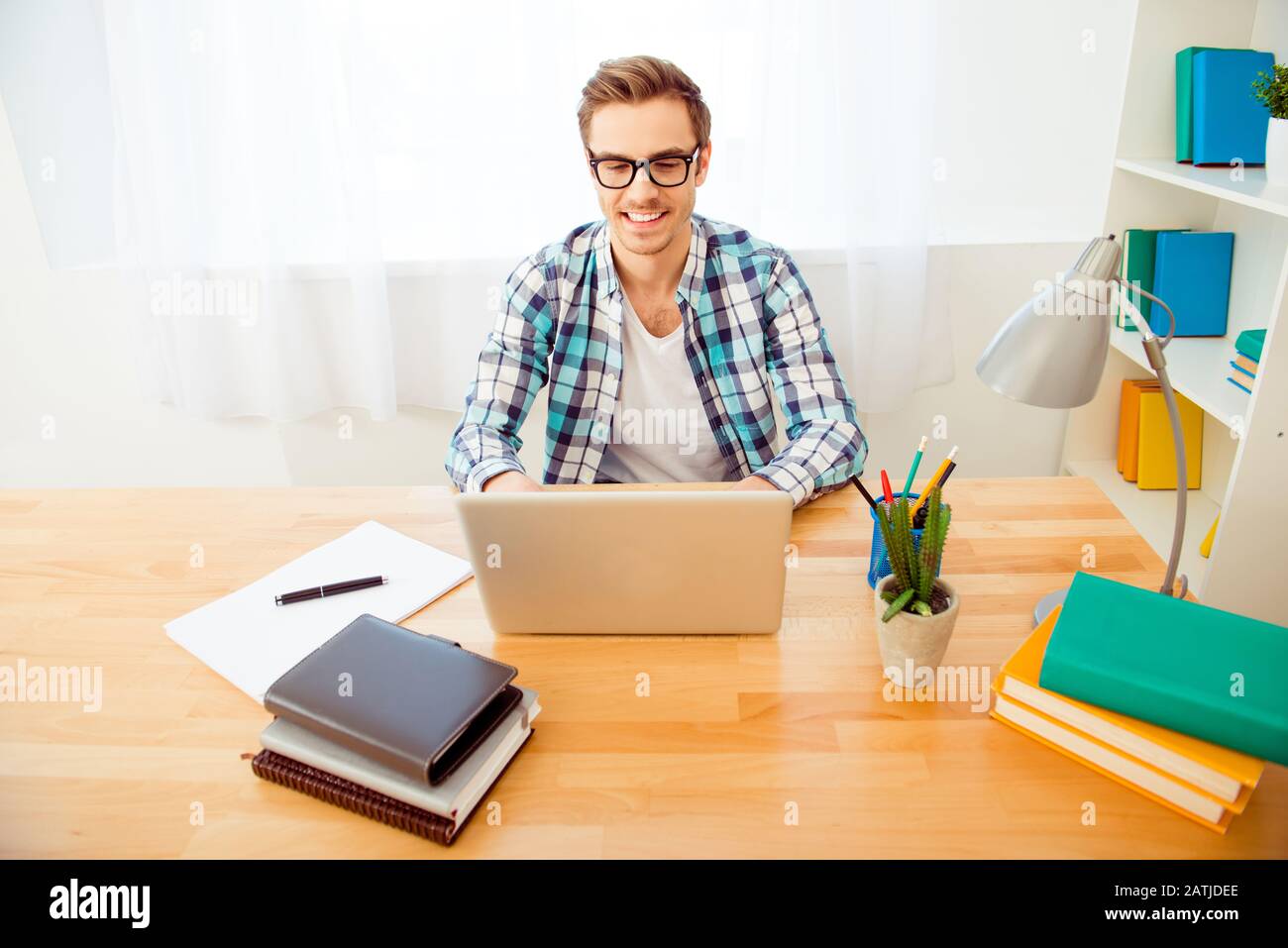 Allegro ragazzo in occhiali scrivere il suo nuovo libro Foto Stock
