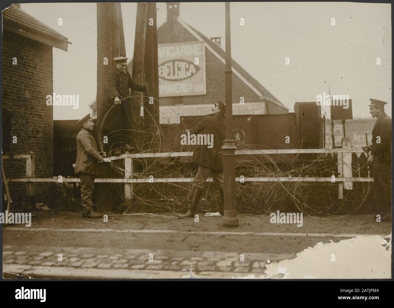 Descrizione: Gruppo di uomini in uniforme lavorando con disfacimento di una palla di filo in una città fiamminga Data: {1914-1918} posizione: Belgio, Fiandre Parole Chiave: Fili, prima guerra mondiale, uomini, città Foto Stock