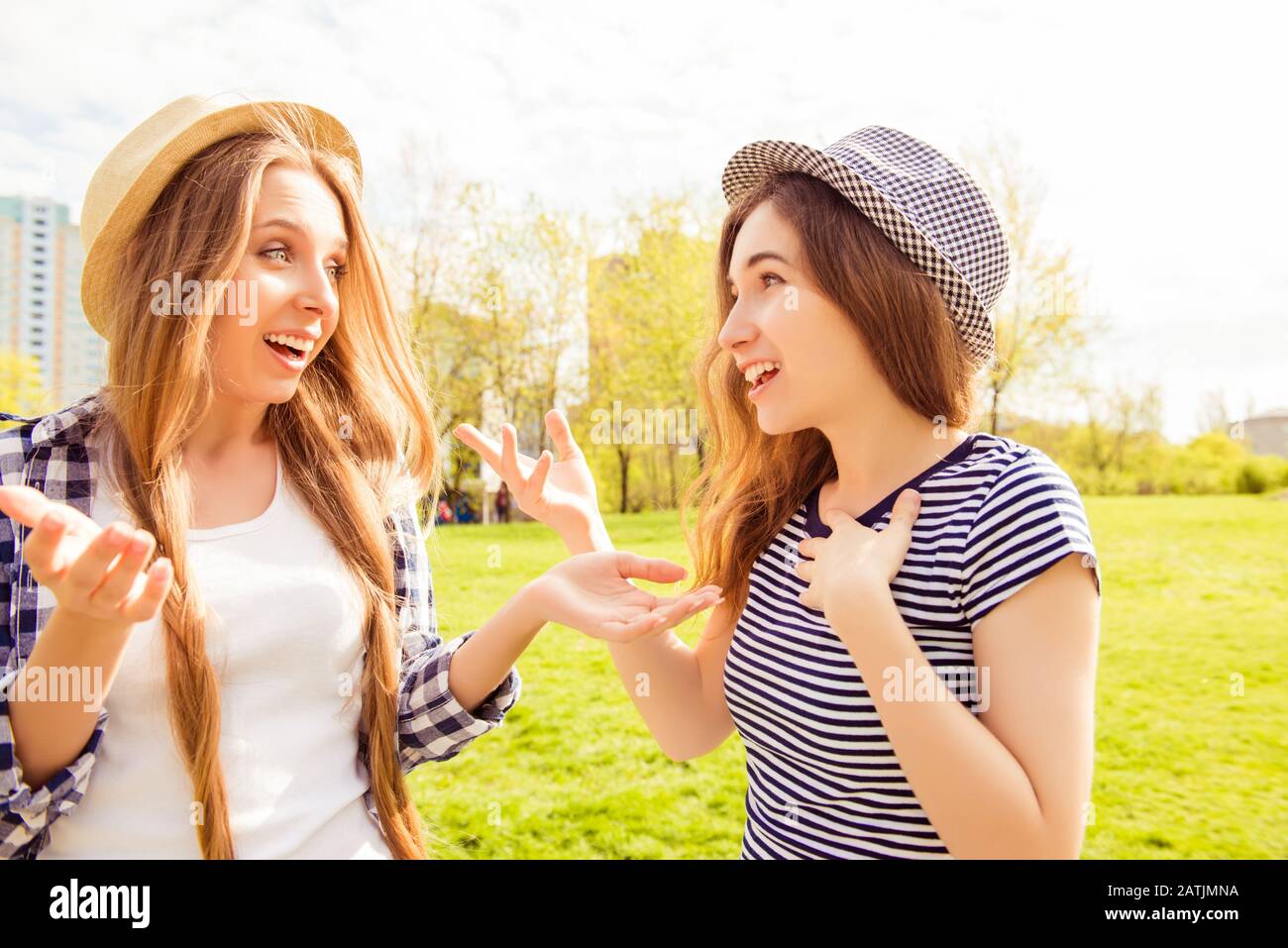 Due ragazze belle eccitate che hanno conversazione nel parco Foto Stock